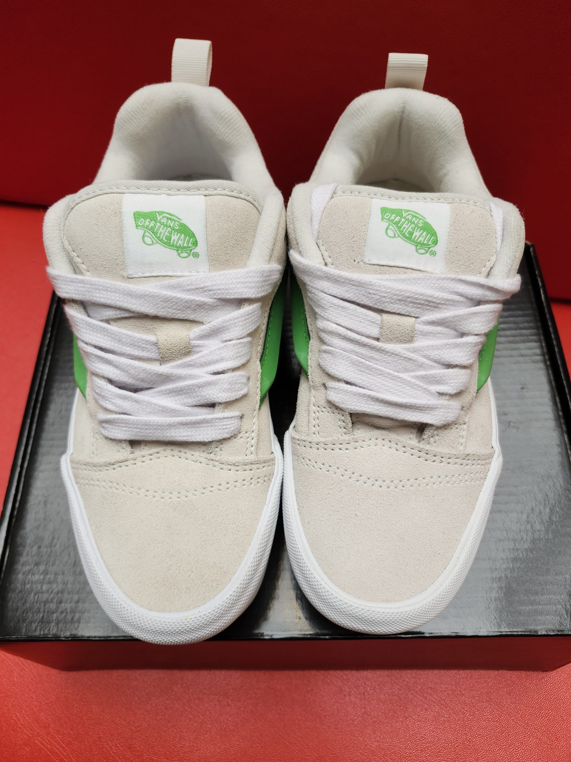 Tan and green Vans sneakers on a white platform sole, with a brown waffle sole.