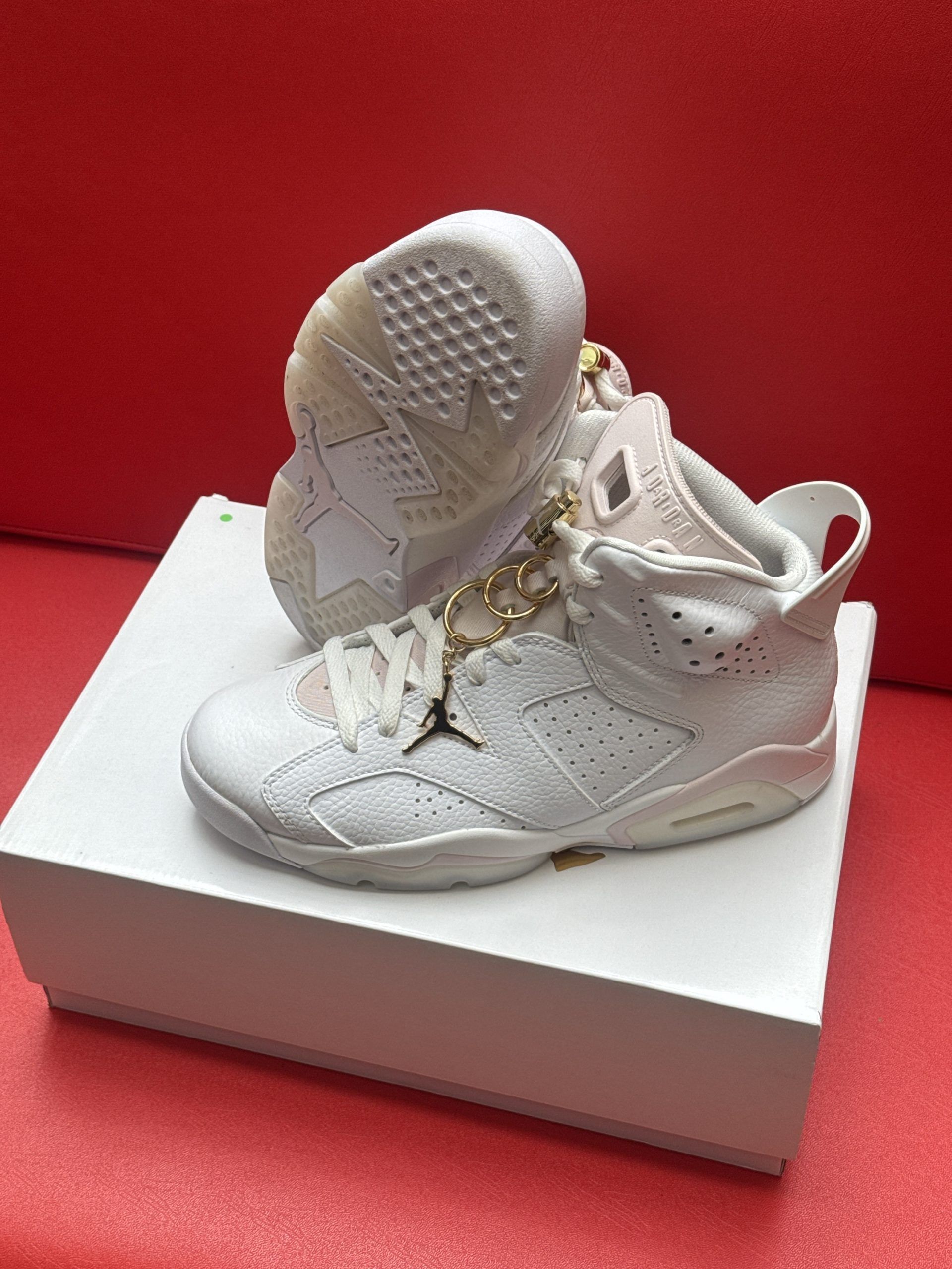 White Air Jordan 6 sneakers on a white box, set against a red background.