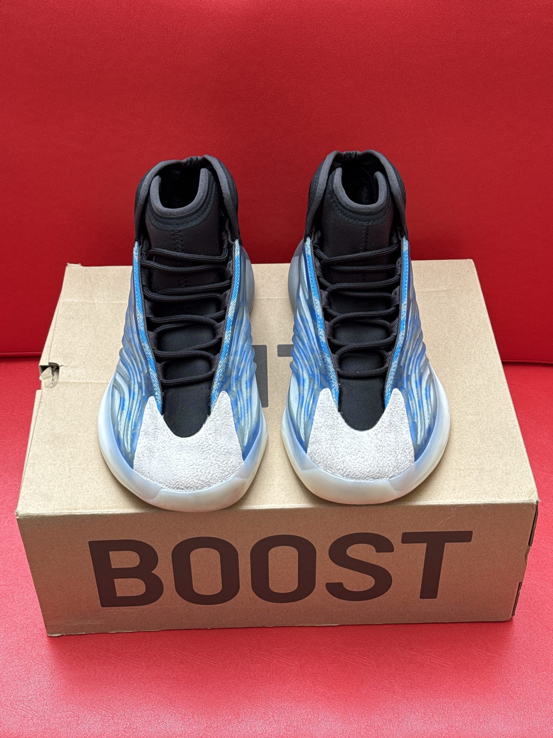 Yeezy basketball sneakers, blue and gray with a clear sole, on a cardboard box that reads 