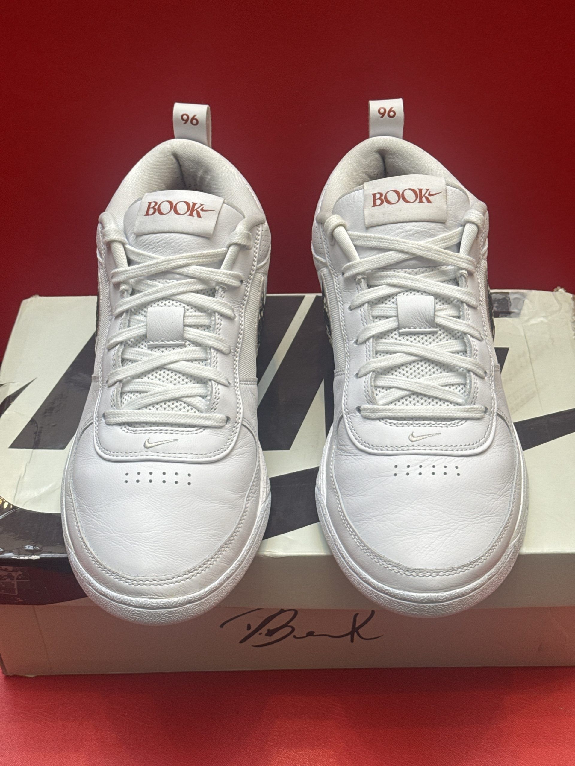 White Nike shoes on a shoebox, one shoe angled to show the sole.