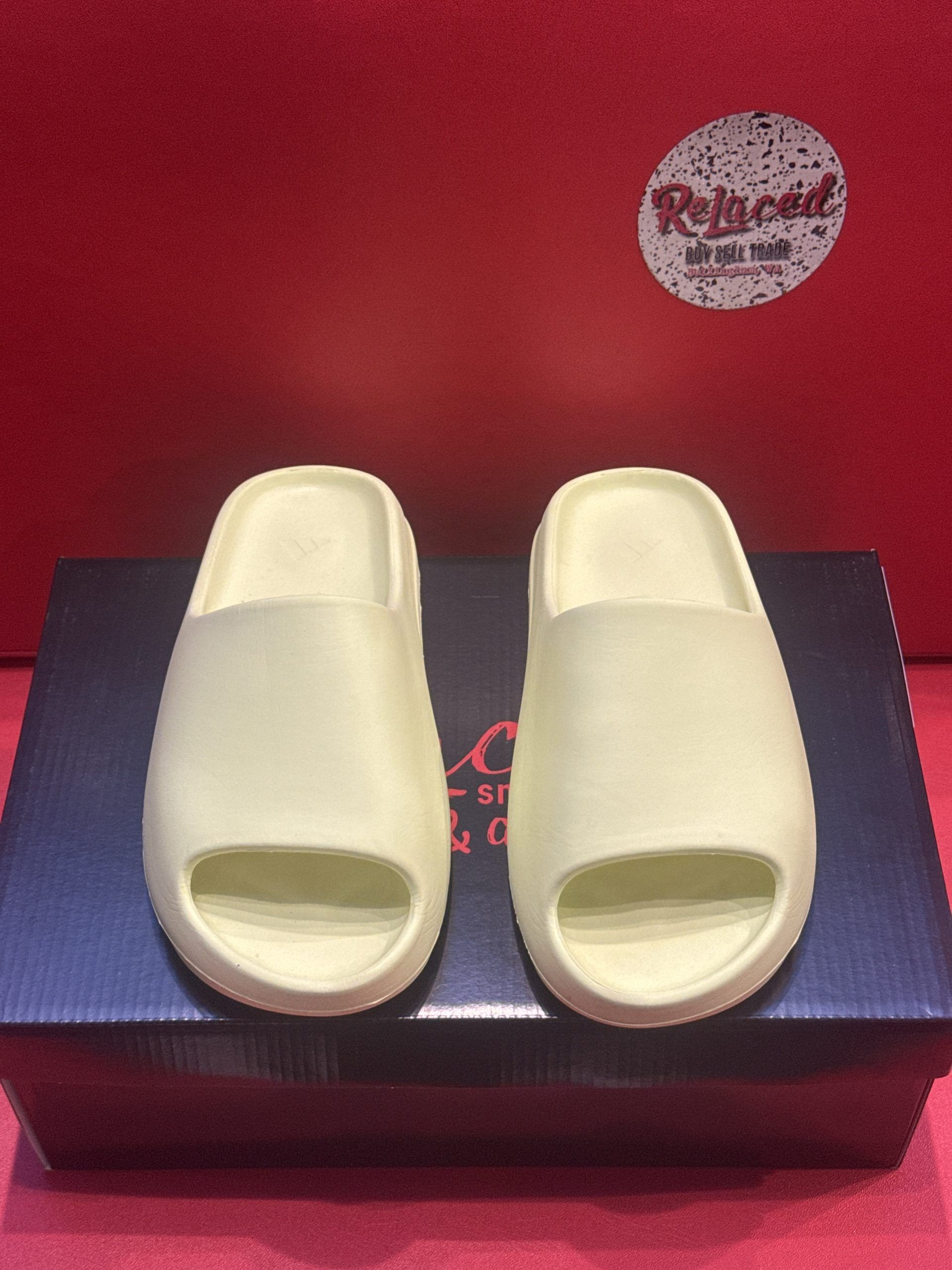 Light green slides on a black box, set against a red background. 