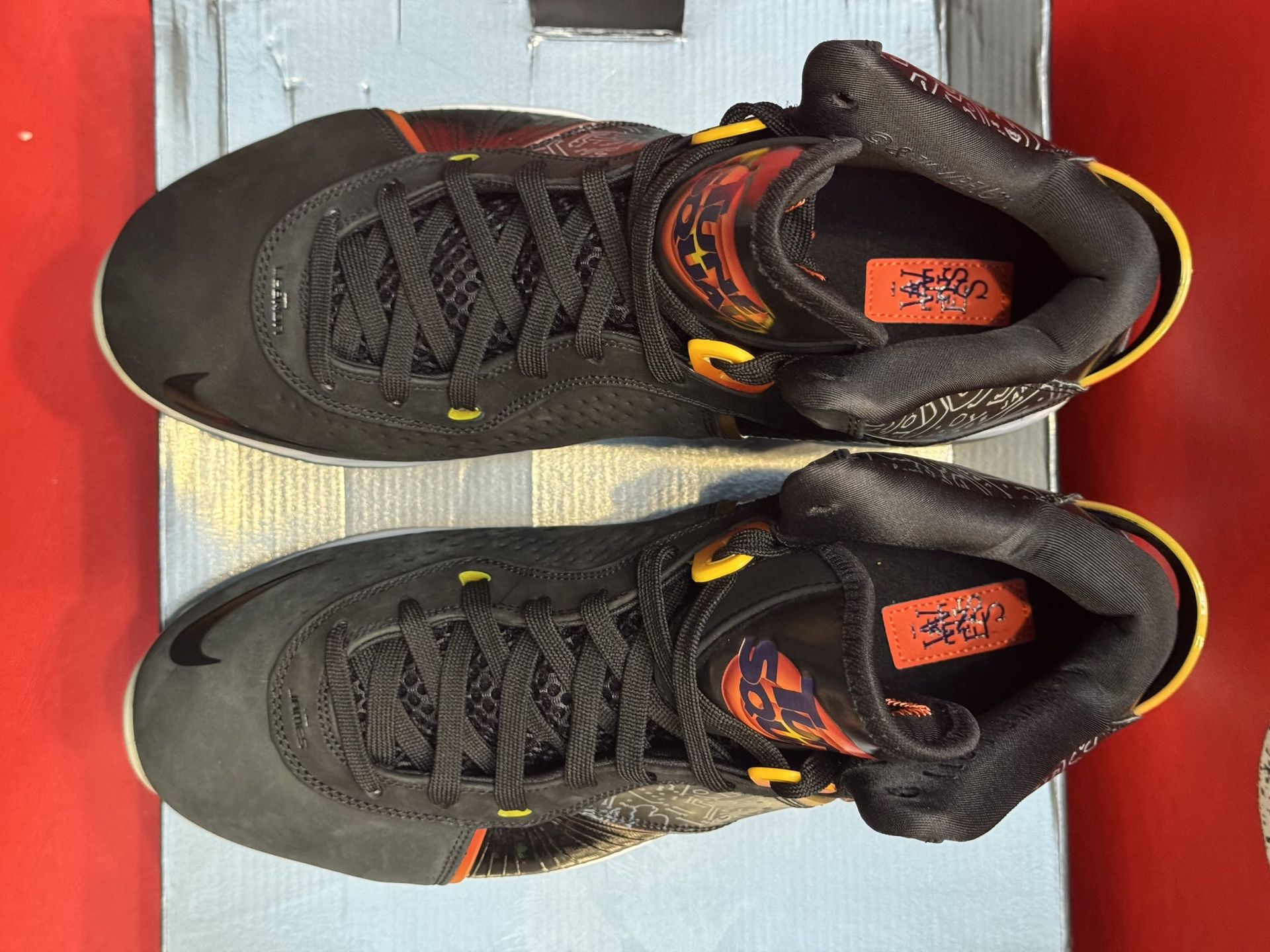 Black and gold Nike LeBron 8 sneakers on a shoebox.