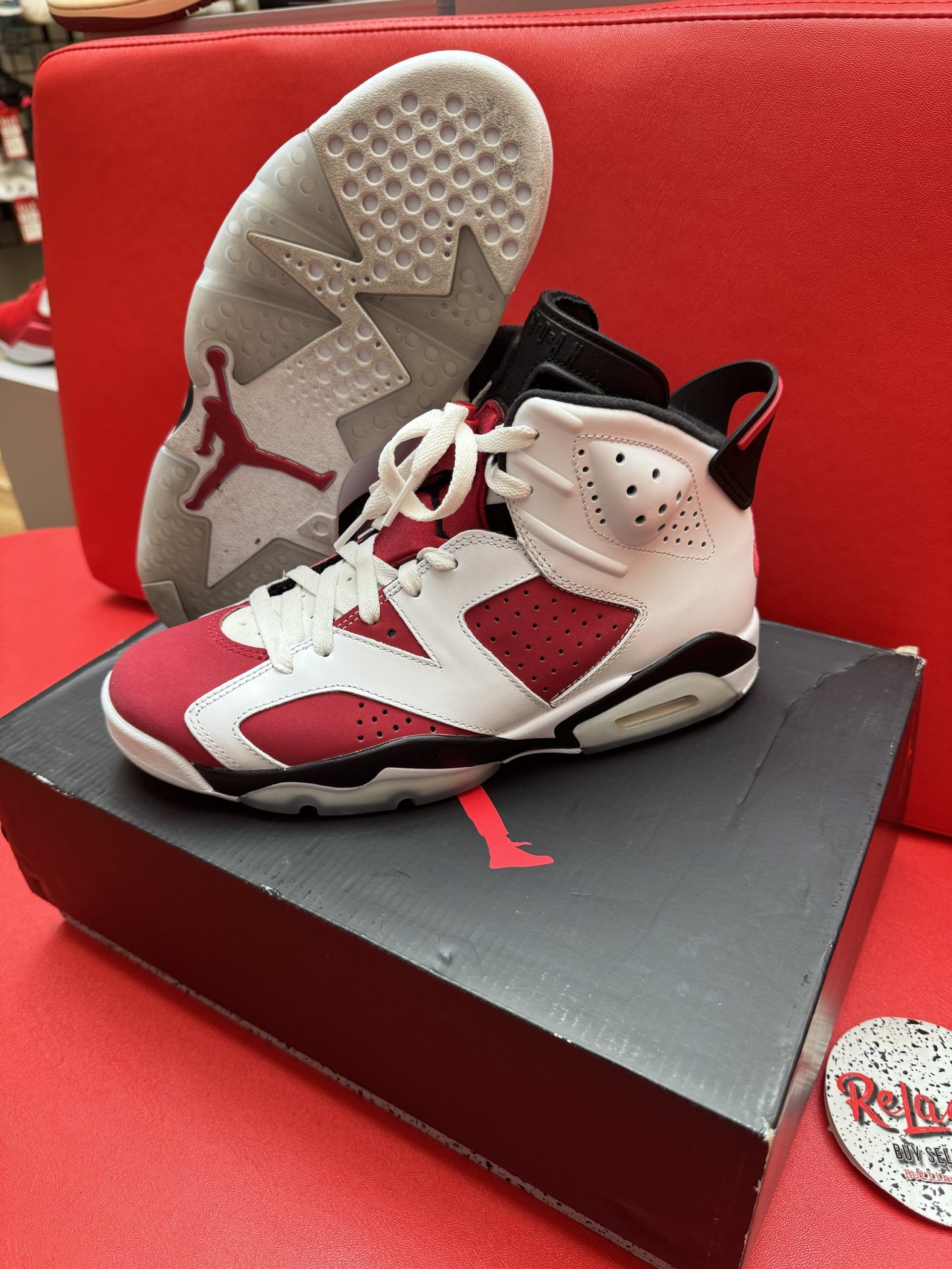 Air Jordan 6 sneakers, red and white, on a box, with the sole visible.