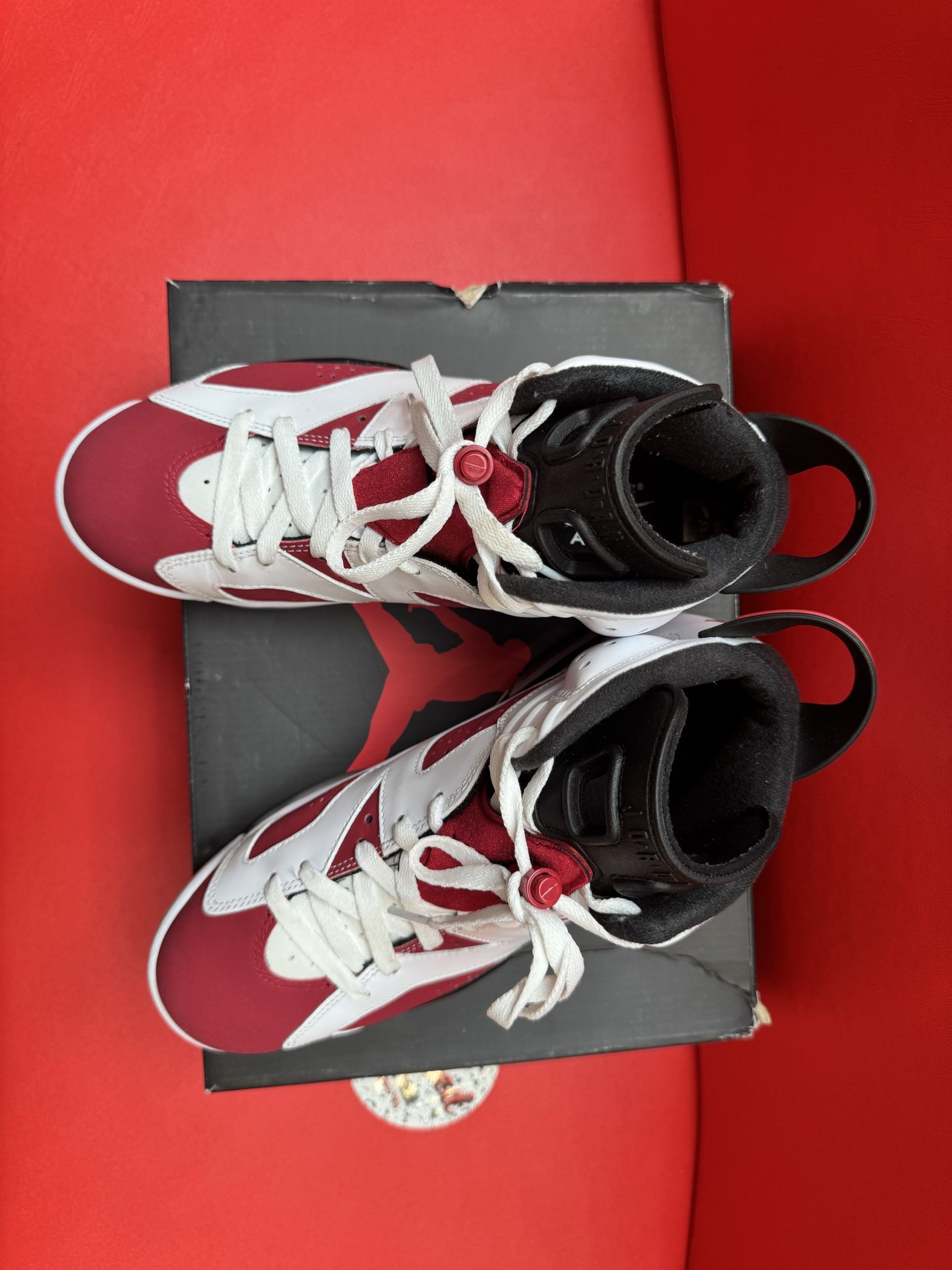 Air Jordan 6 sneakers, red and white, on a box, with the sole visible.