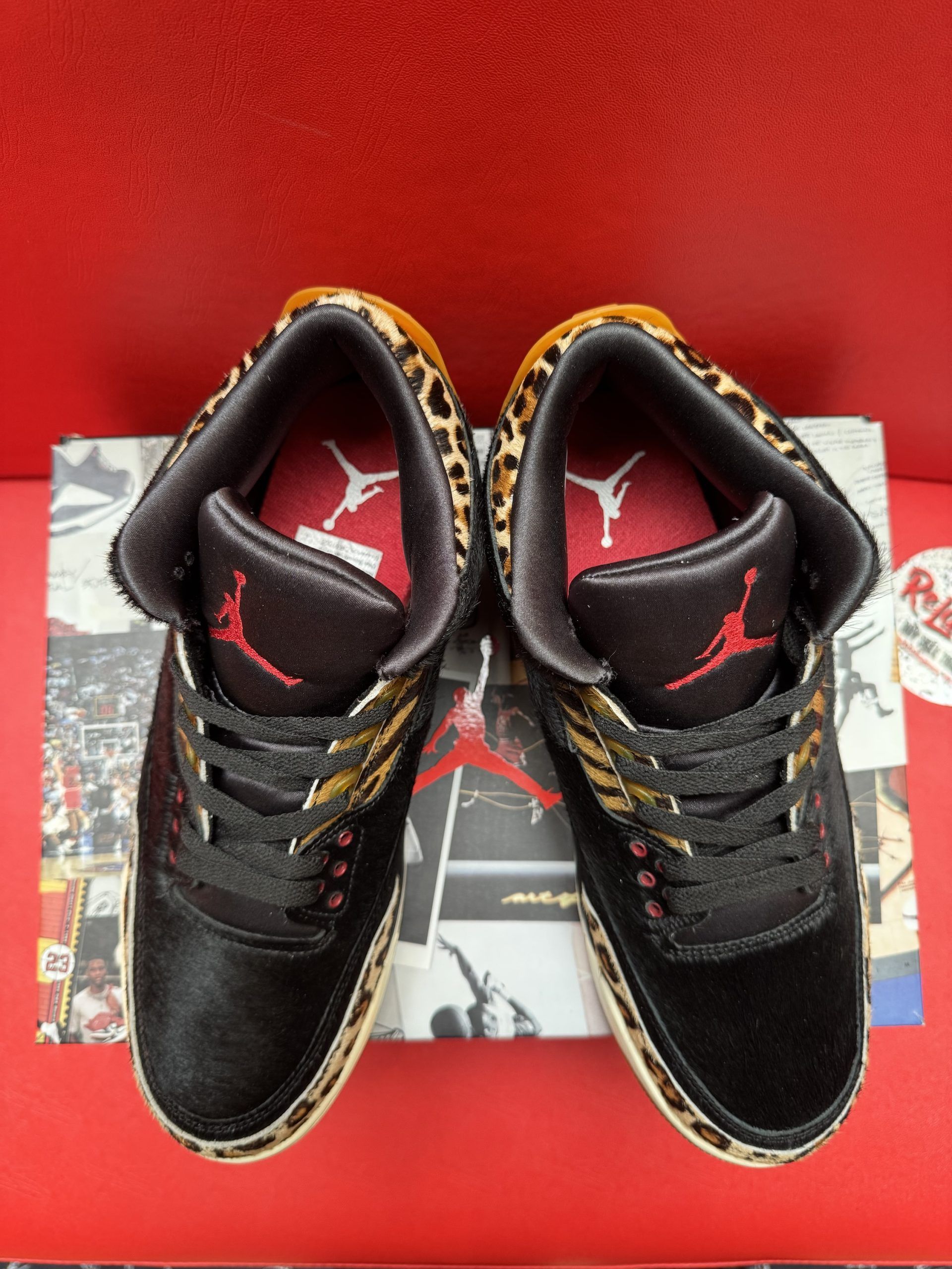 Black and animal print Air Jordan 3 sneakers on a box, with a gum sole in view.