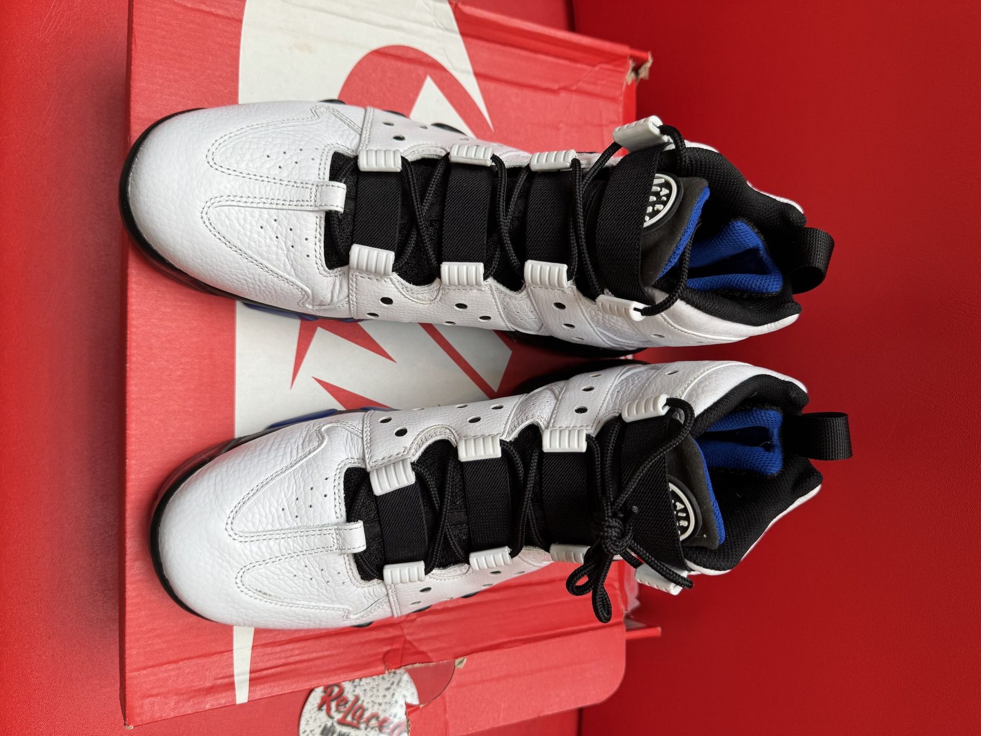 White and black Nike Barkley basketball sneaker with blue accents on a Nike box.