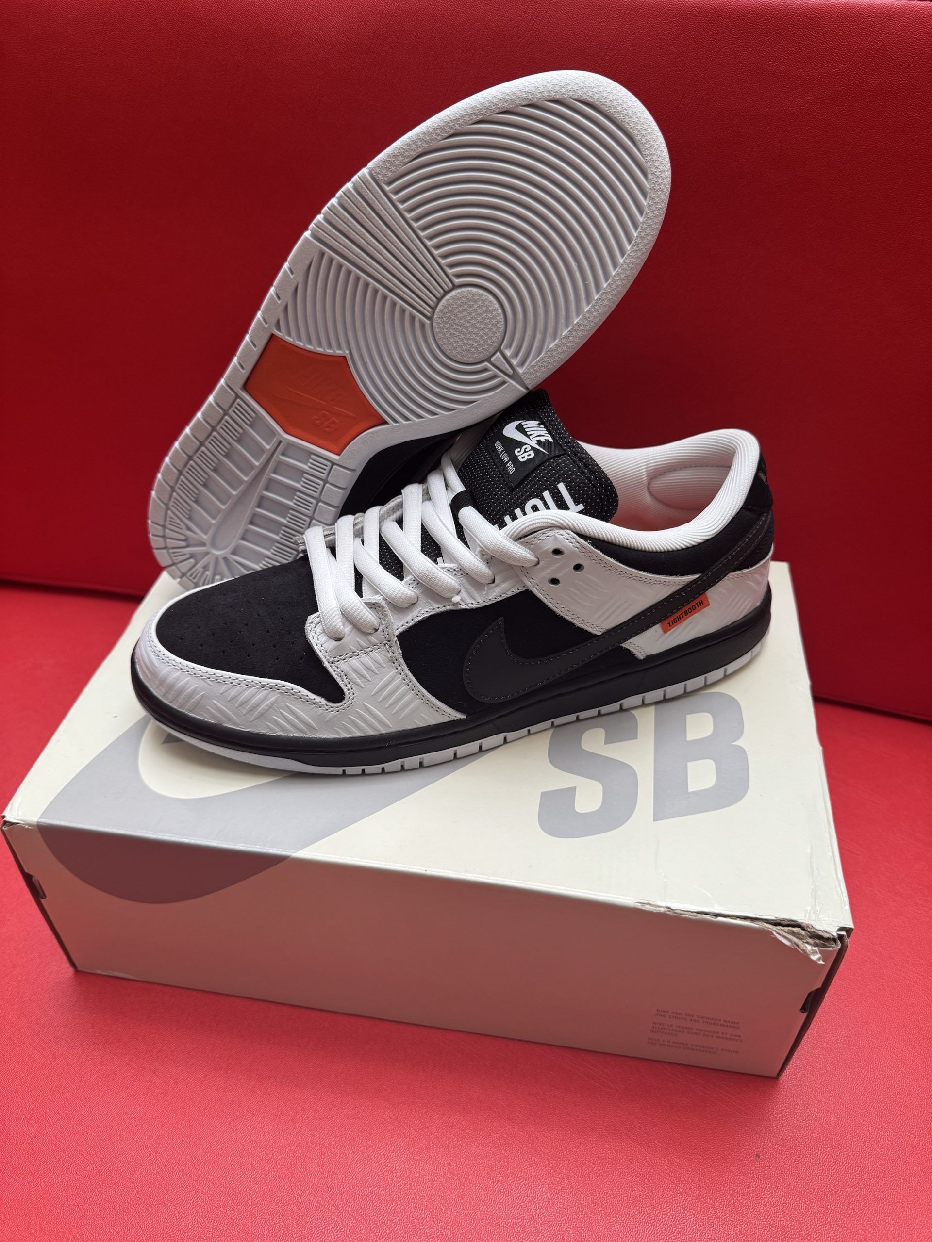 Nike SB Dunk Low sneakers in black and white, resting on a shoebox.