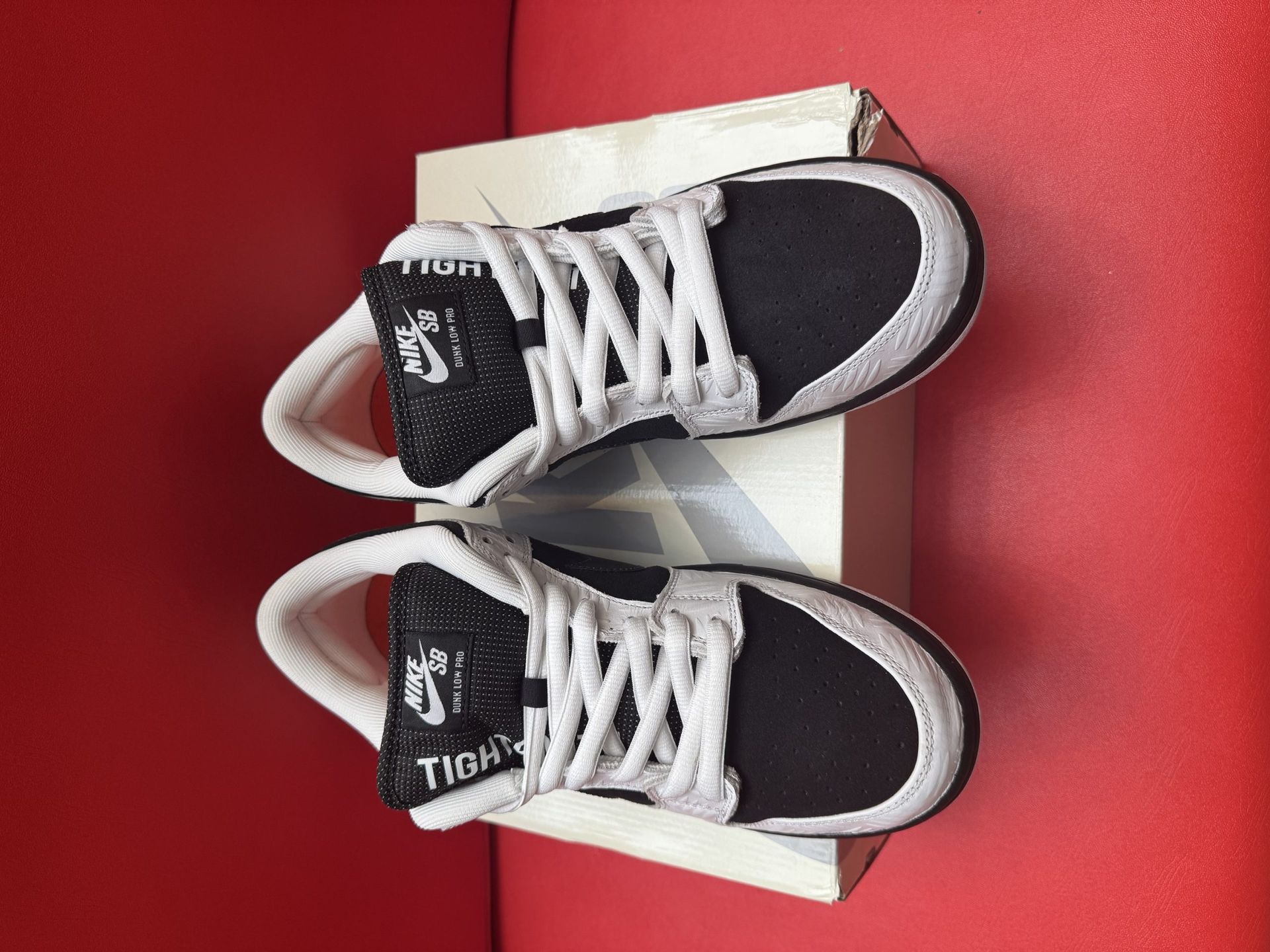 Nike SB Dunk Low sneakers in black and white, resting on a shoebox.