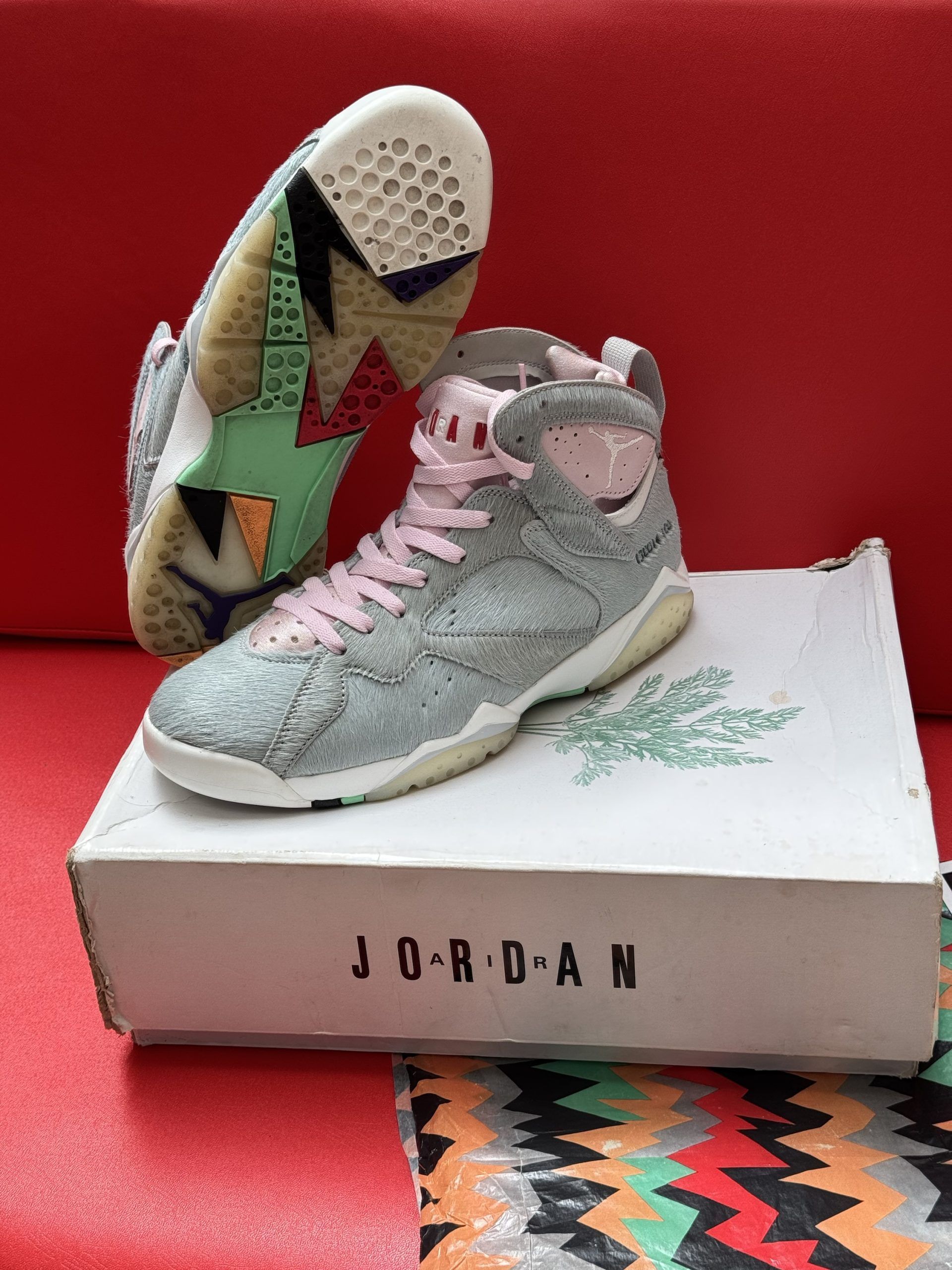 Air Jordan 7 sneakers in gray with pink laces on a white Jordan box.