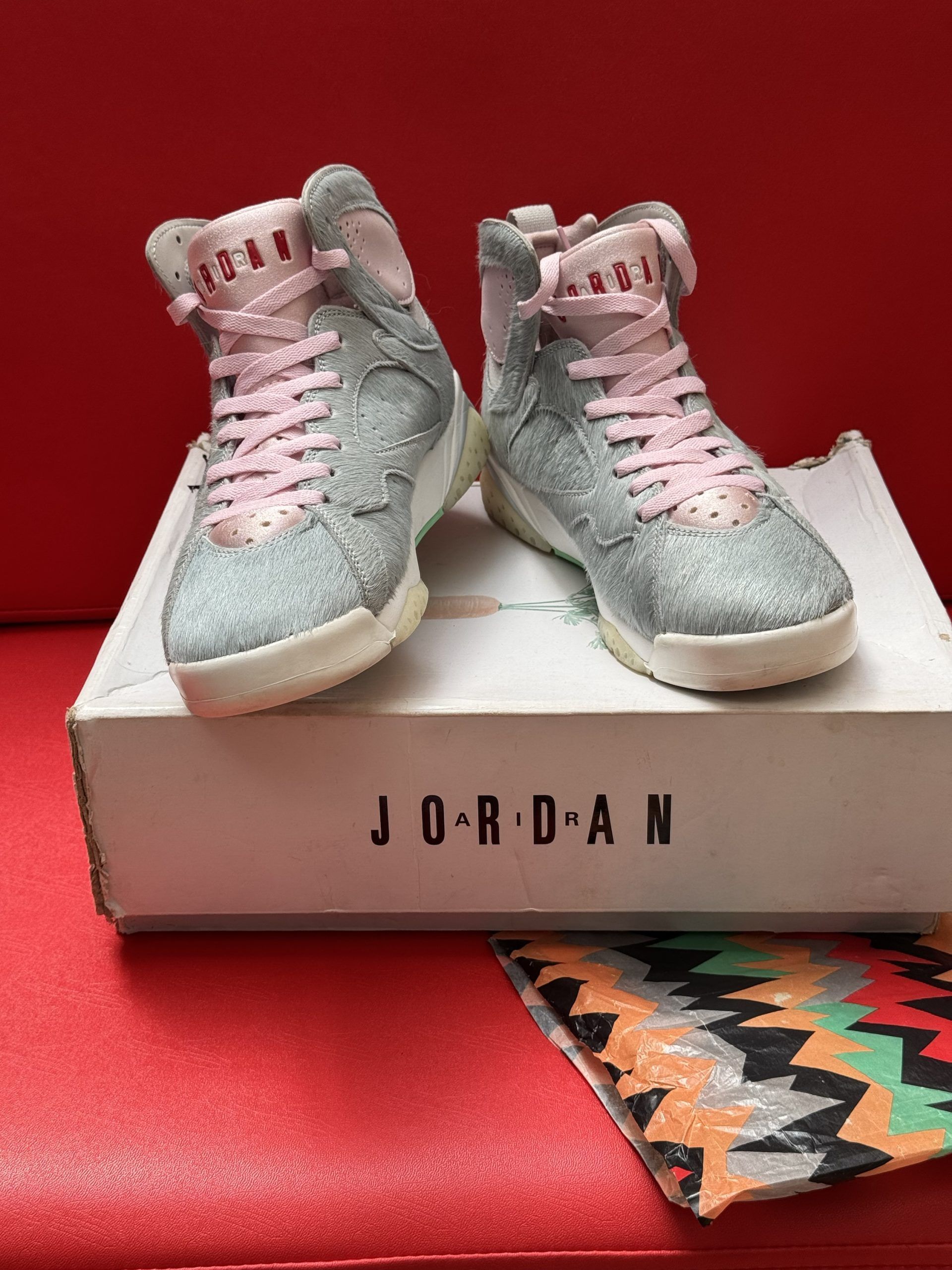 Air Jordan 7 sneakers in gray with pink laces on a white Jordan box.