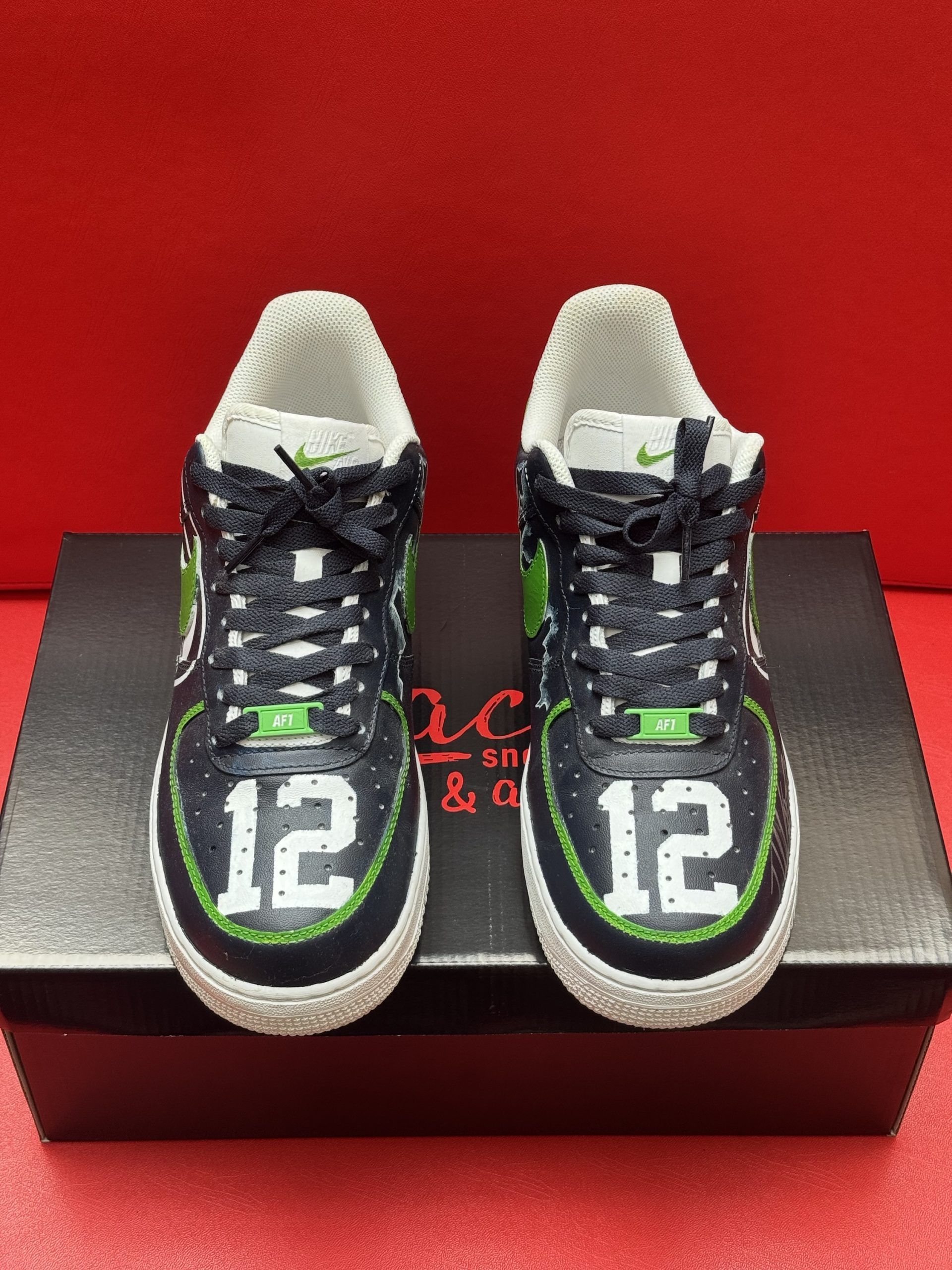 Custom Seahawks Nike Air Force 1 shoe with green and blue accents on a box.