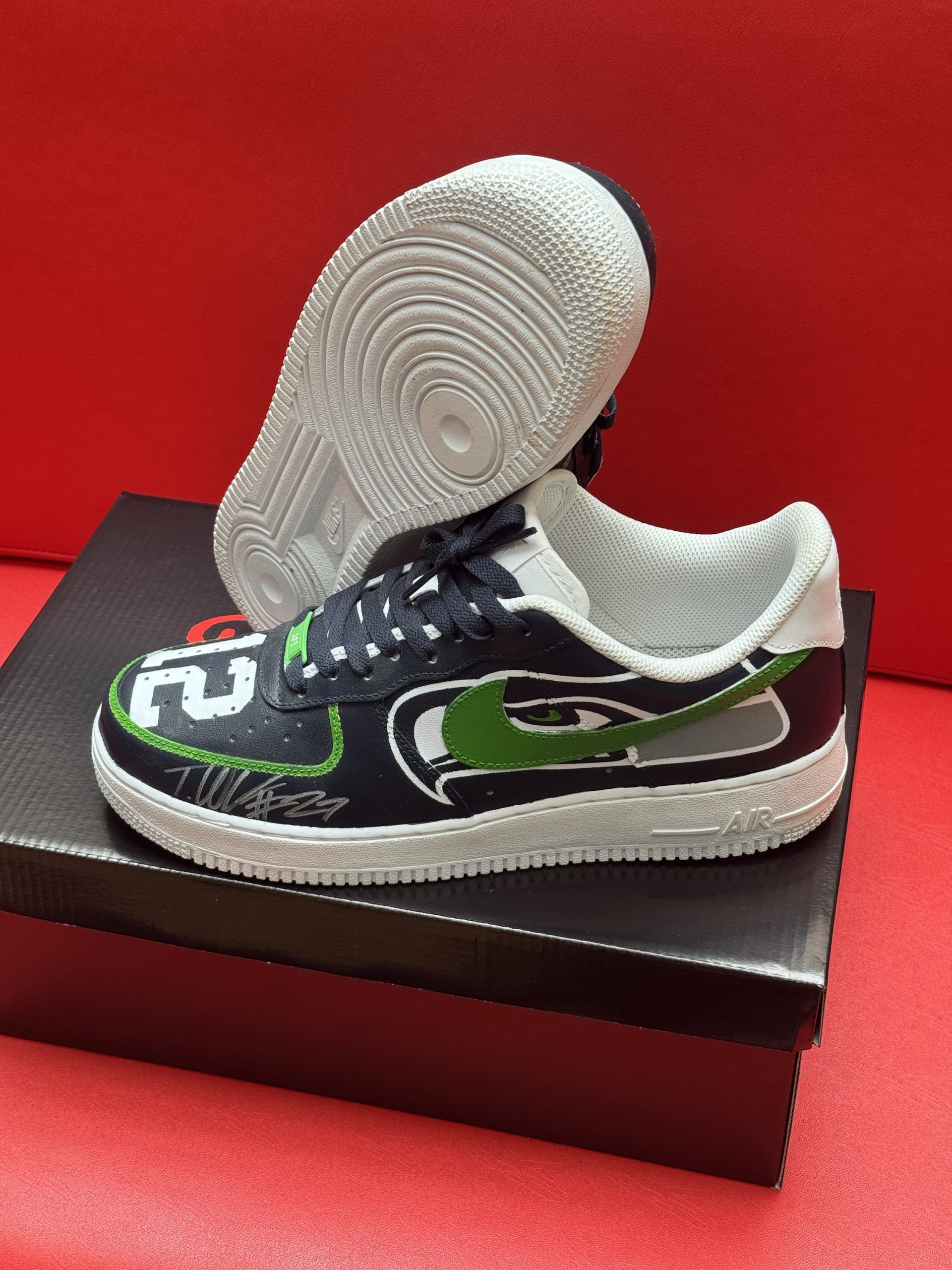 Custom Seahawks Nike Air Force 1 shoe with green and blue accents on a box.