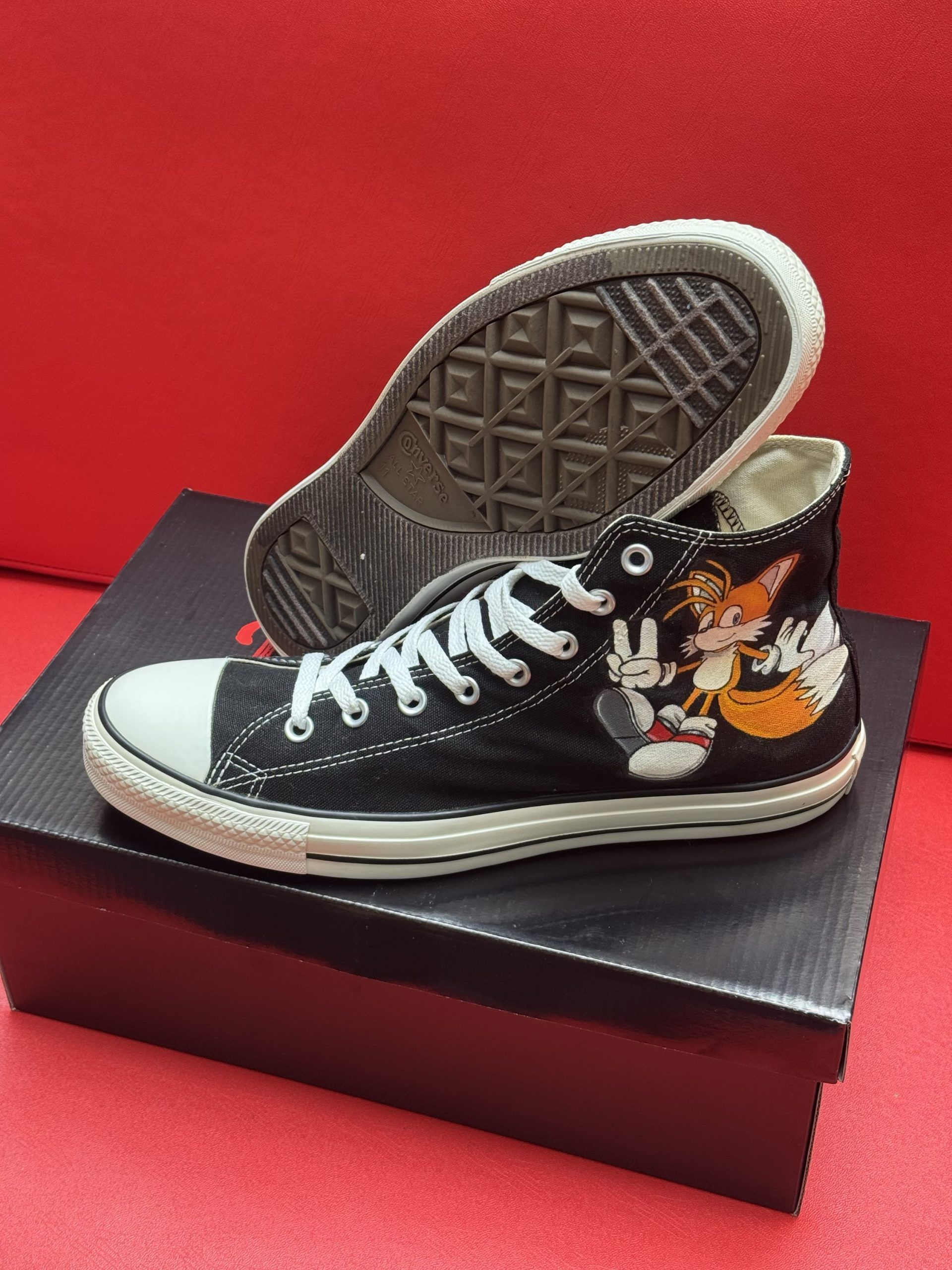 Black high-top sneakers with embroidered Sonic the Hedgehog and Tails characters on a red background.