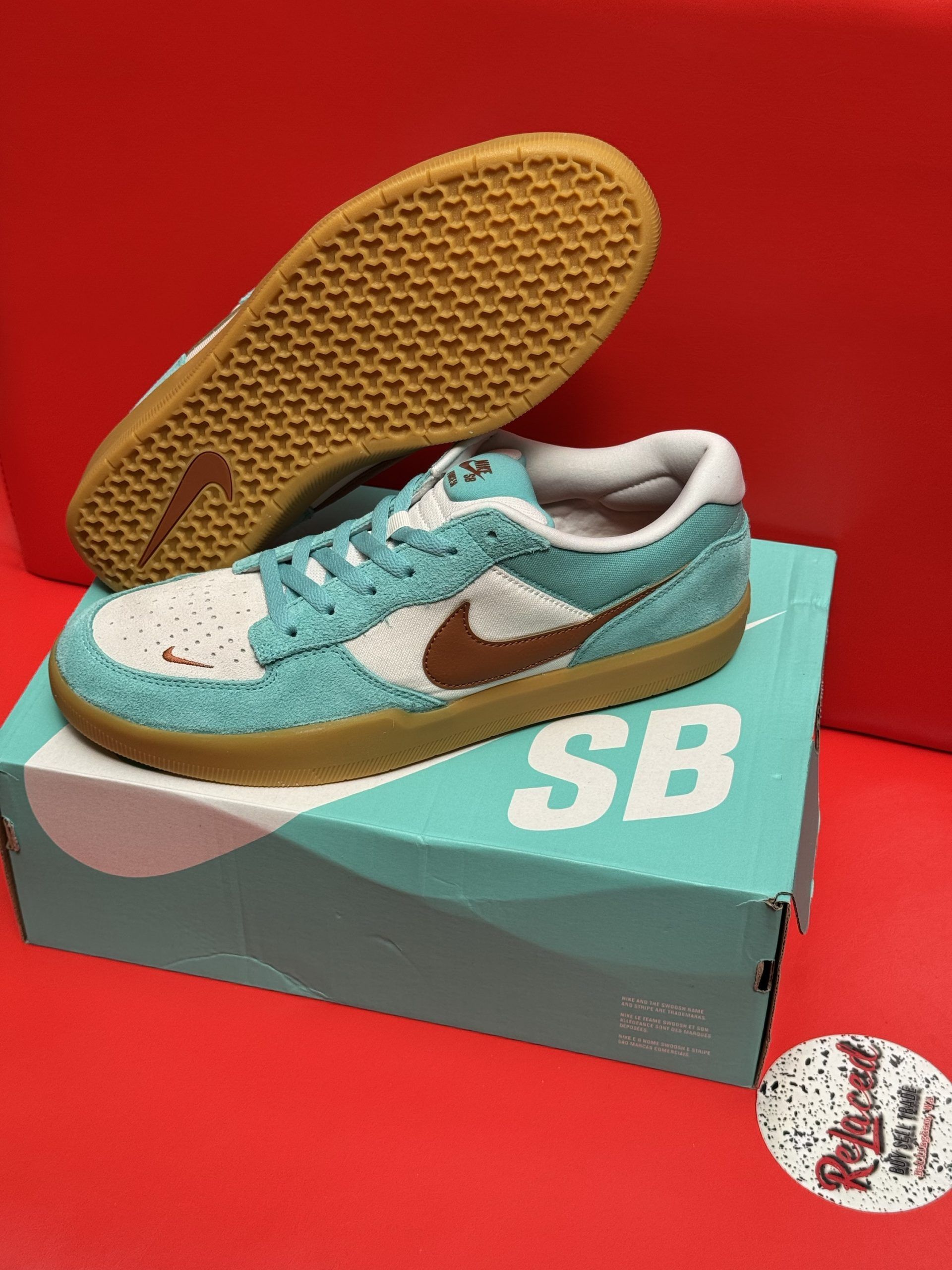 Blue and white Nike SB Dunk Low sneakers with brown accents, resting on a box.