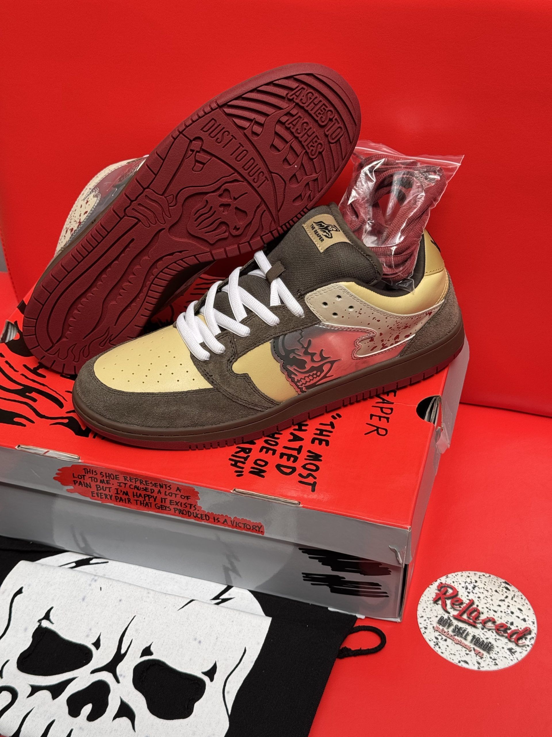 Pair of brown and tan sneakers with red accents on a red box, near a skull-themed bag.