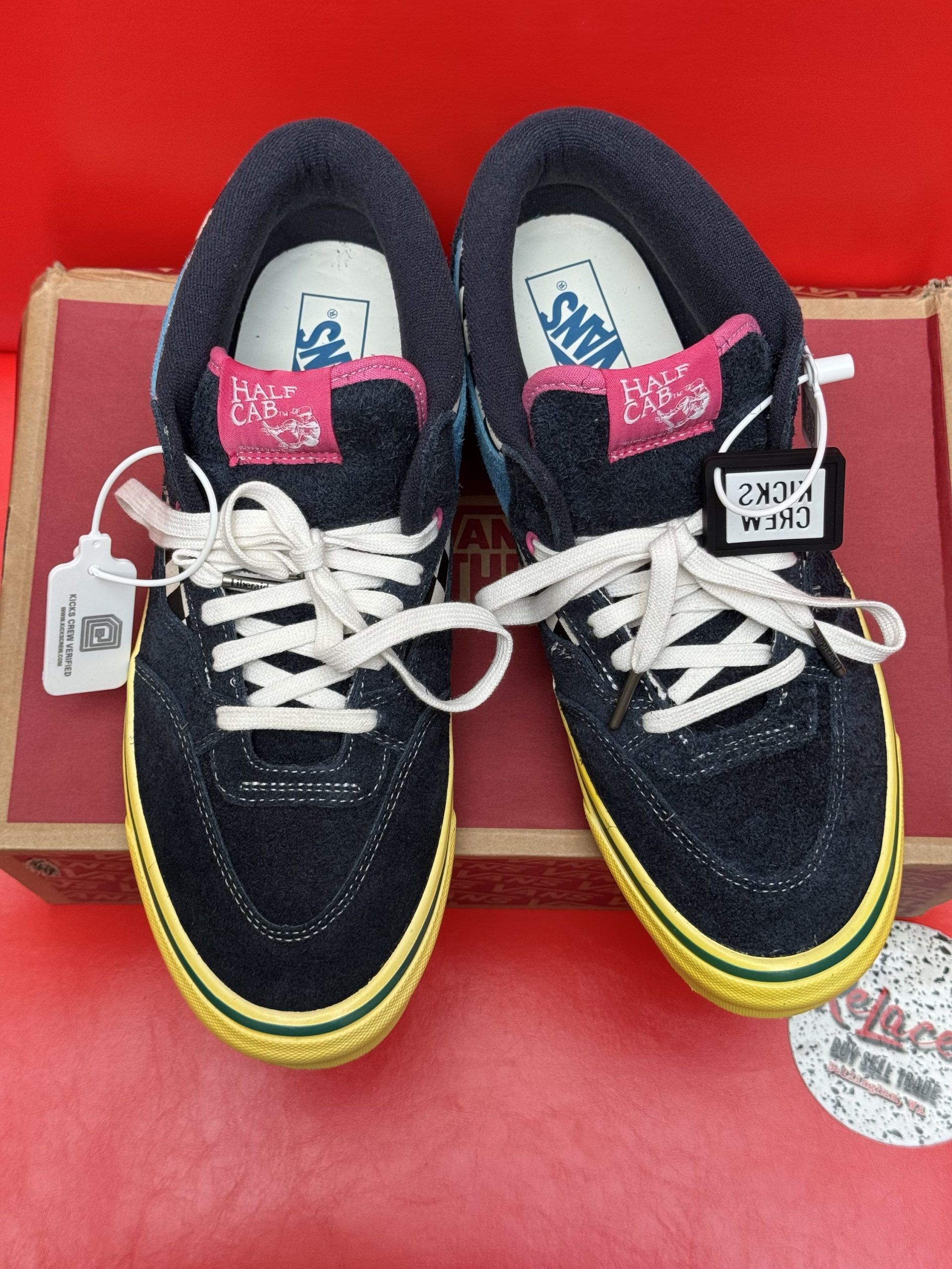Vans Half Cab sneakers on a box. Blue denim, yellow sole, pink accents. One shoe's insole reads 