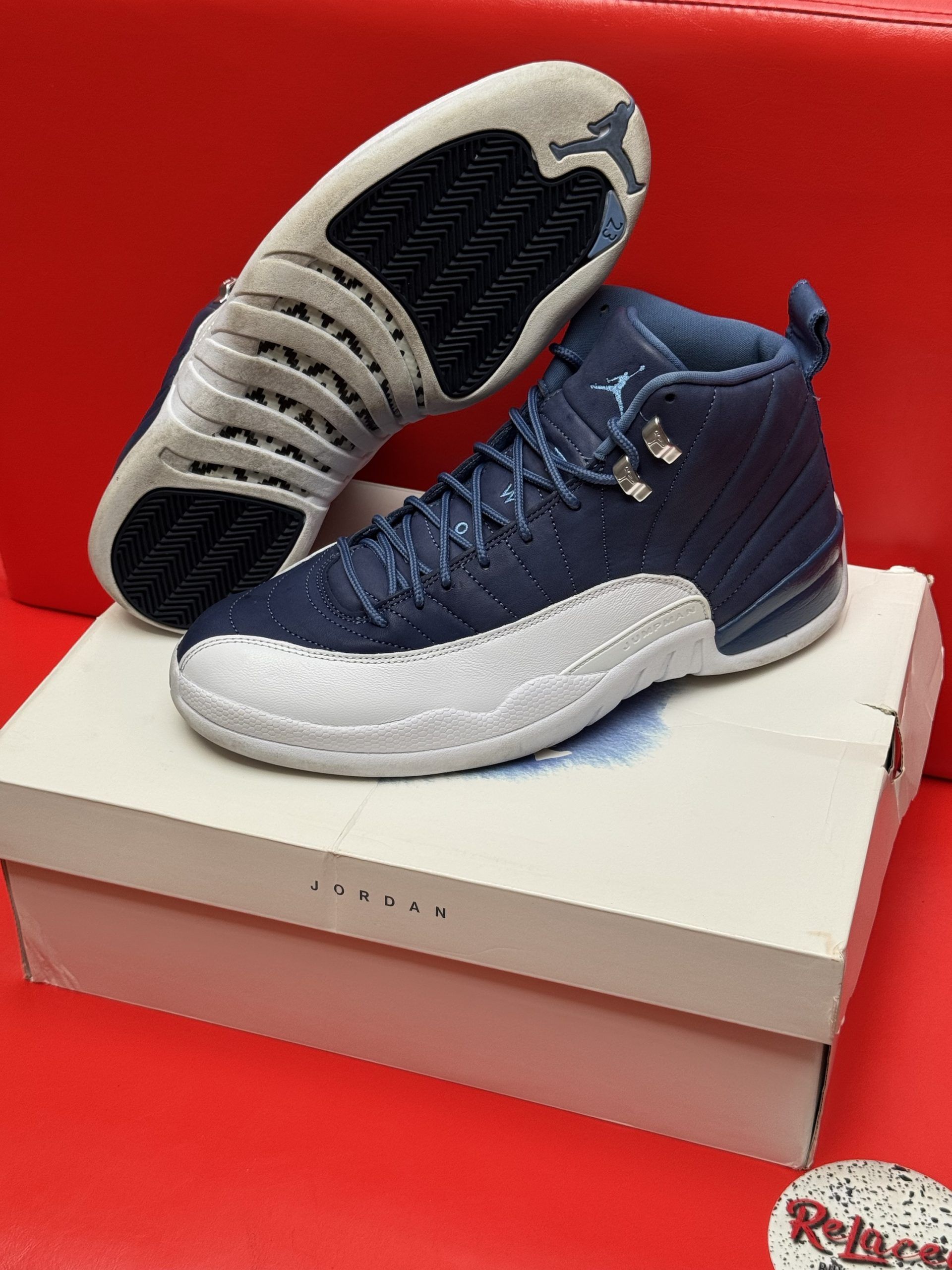 Blue and white Air Jordan 12 sneakers on a box, sole visible.