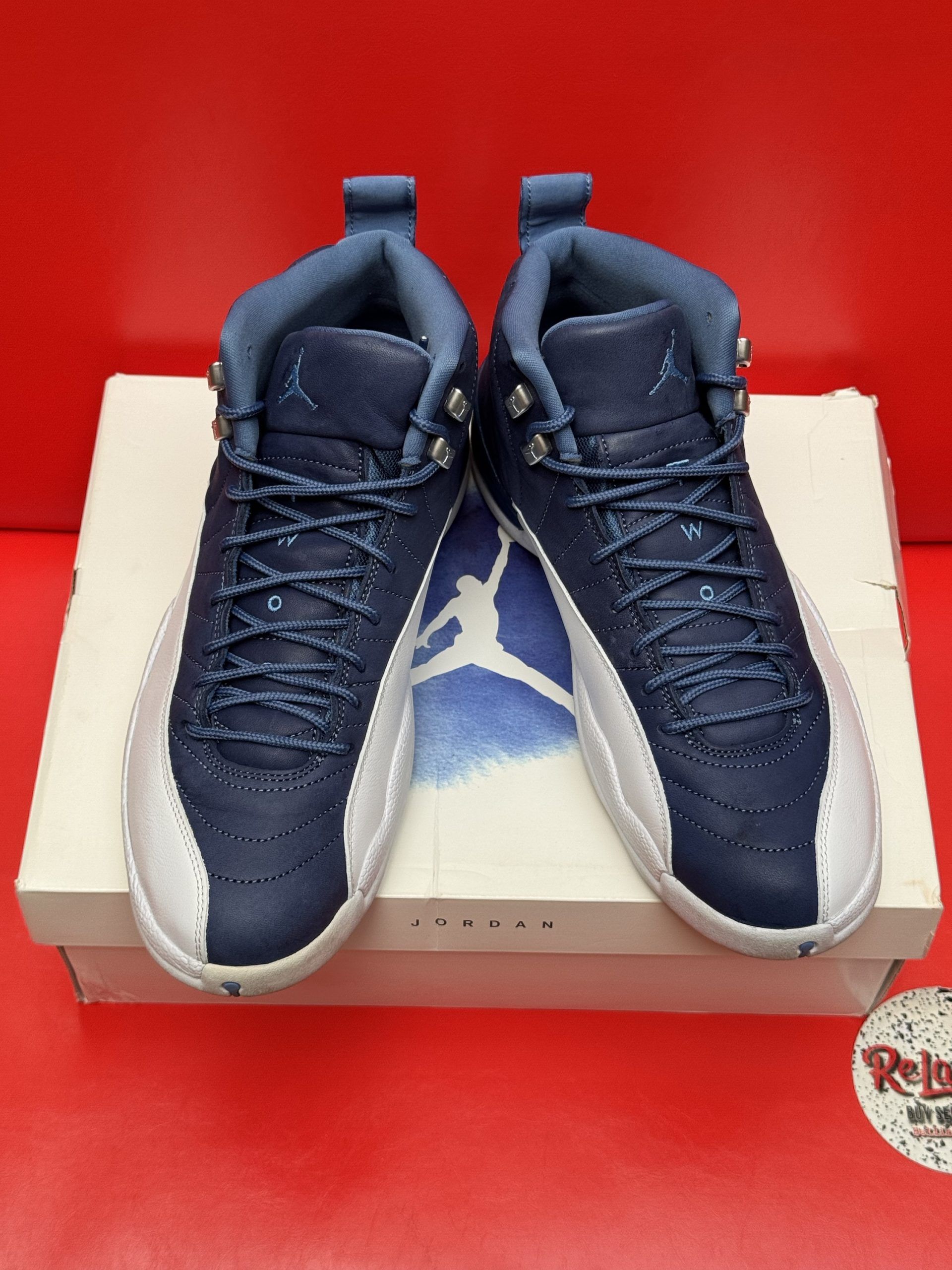 Blue and white Air Jordan 12 sneakers on a box, sole visible.