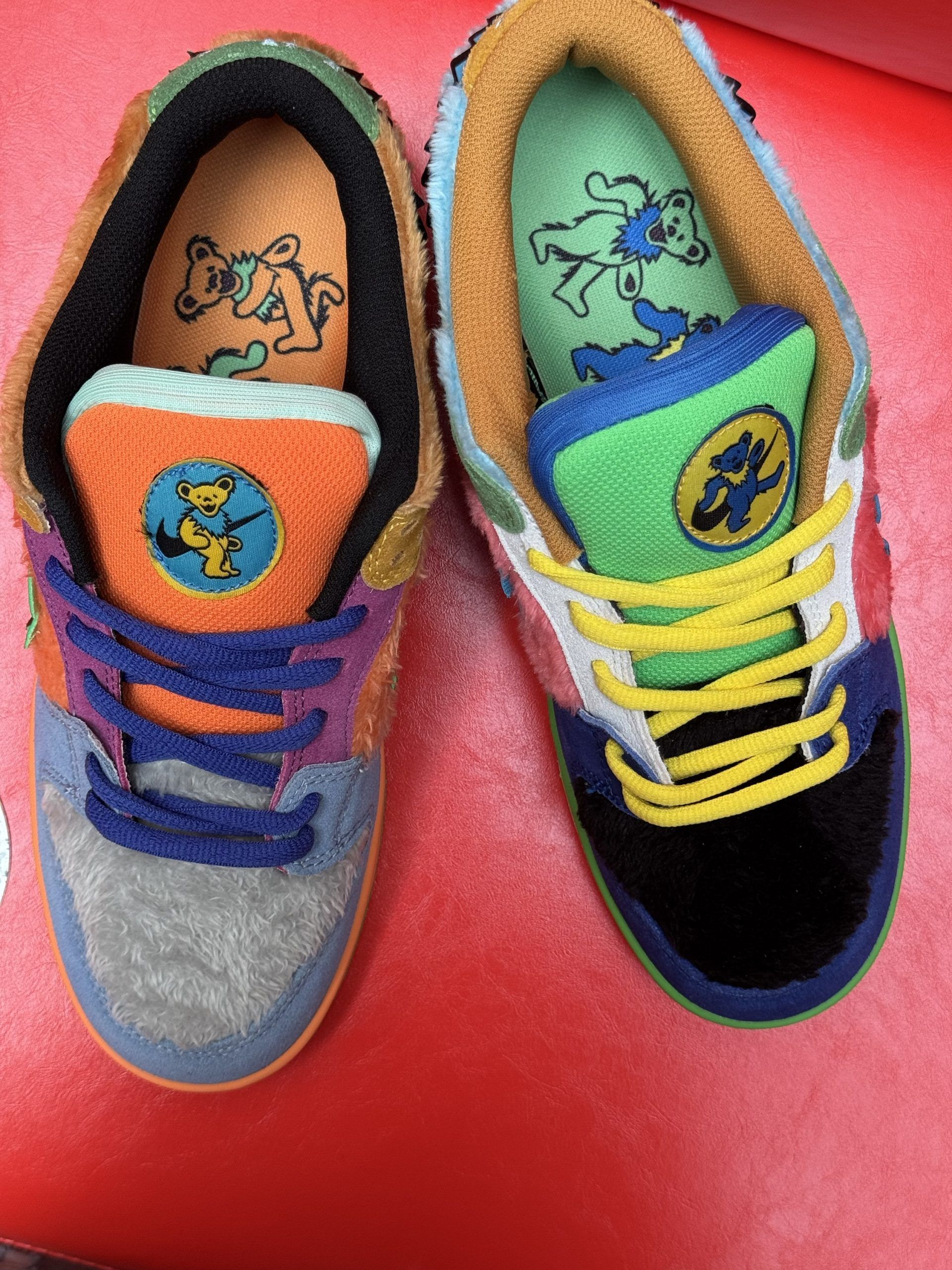 Colorful Nike Dunk Low sneakers with unique textures and patterns on red background.