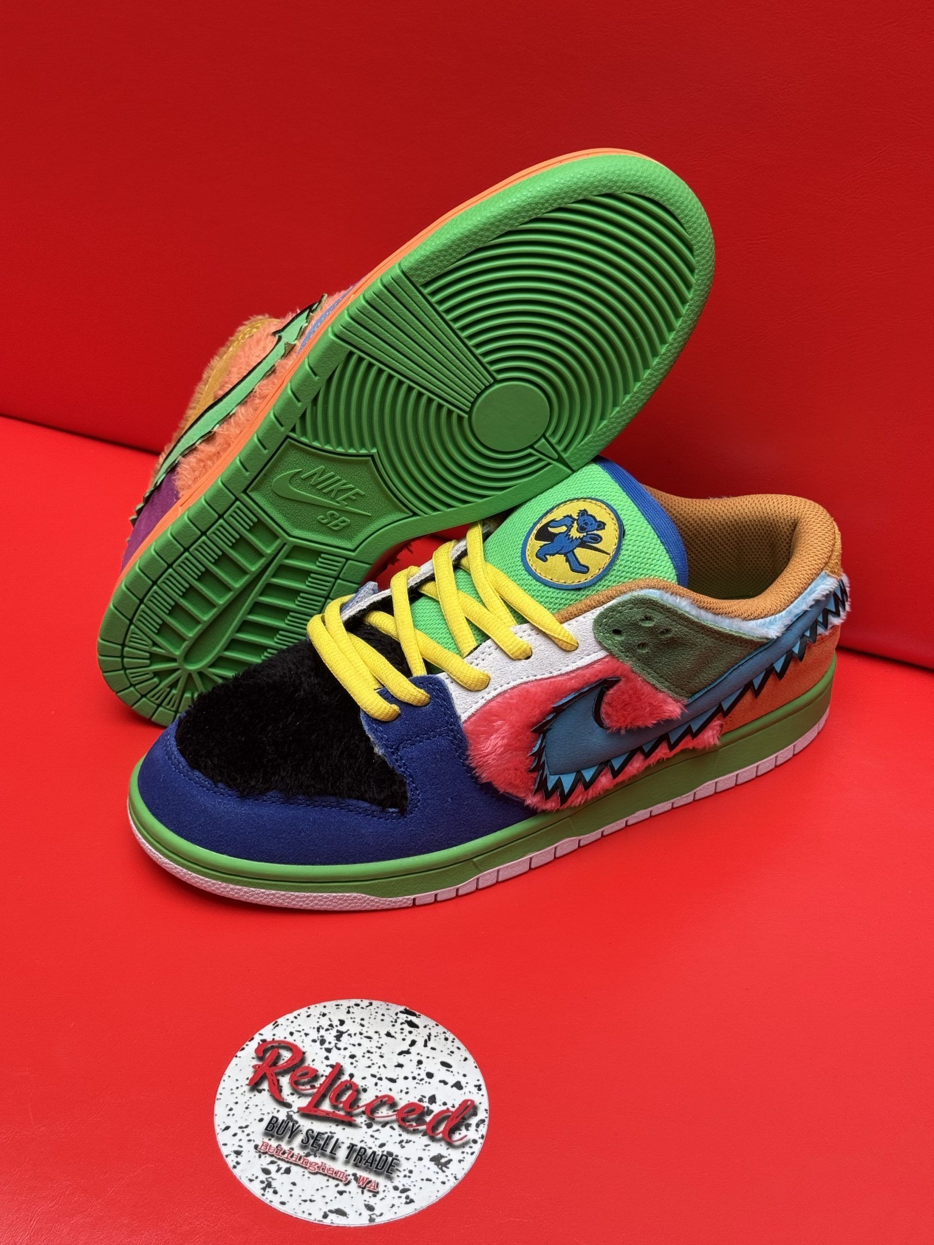 Colorful Nike Dunk Low sneakers with unique textures and patterns on red background.