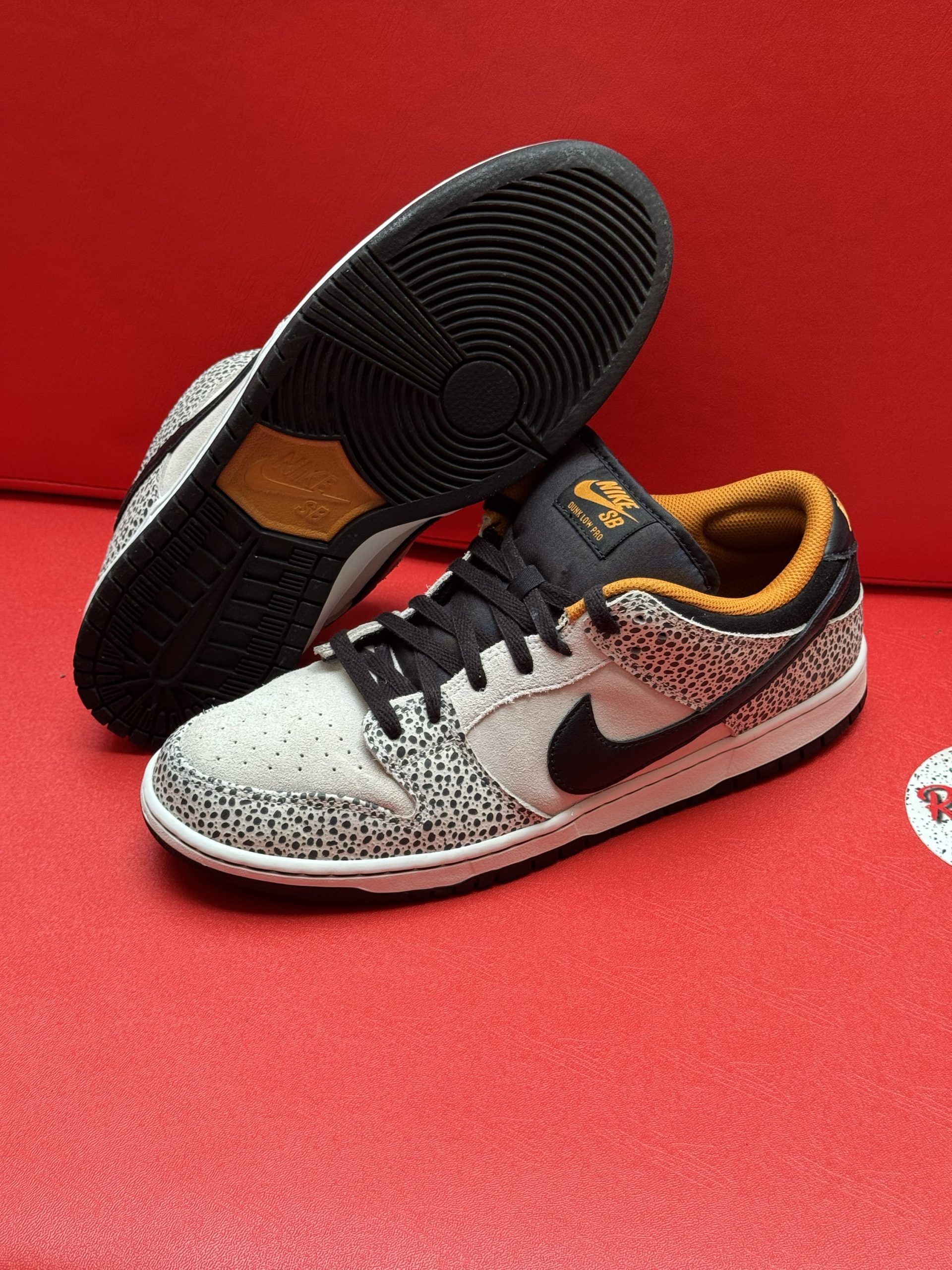 Nike SB Dunk Low sneakers with speckled pattern, black swoosh, and gold accents.