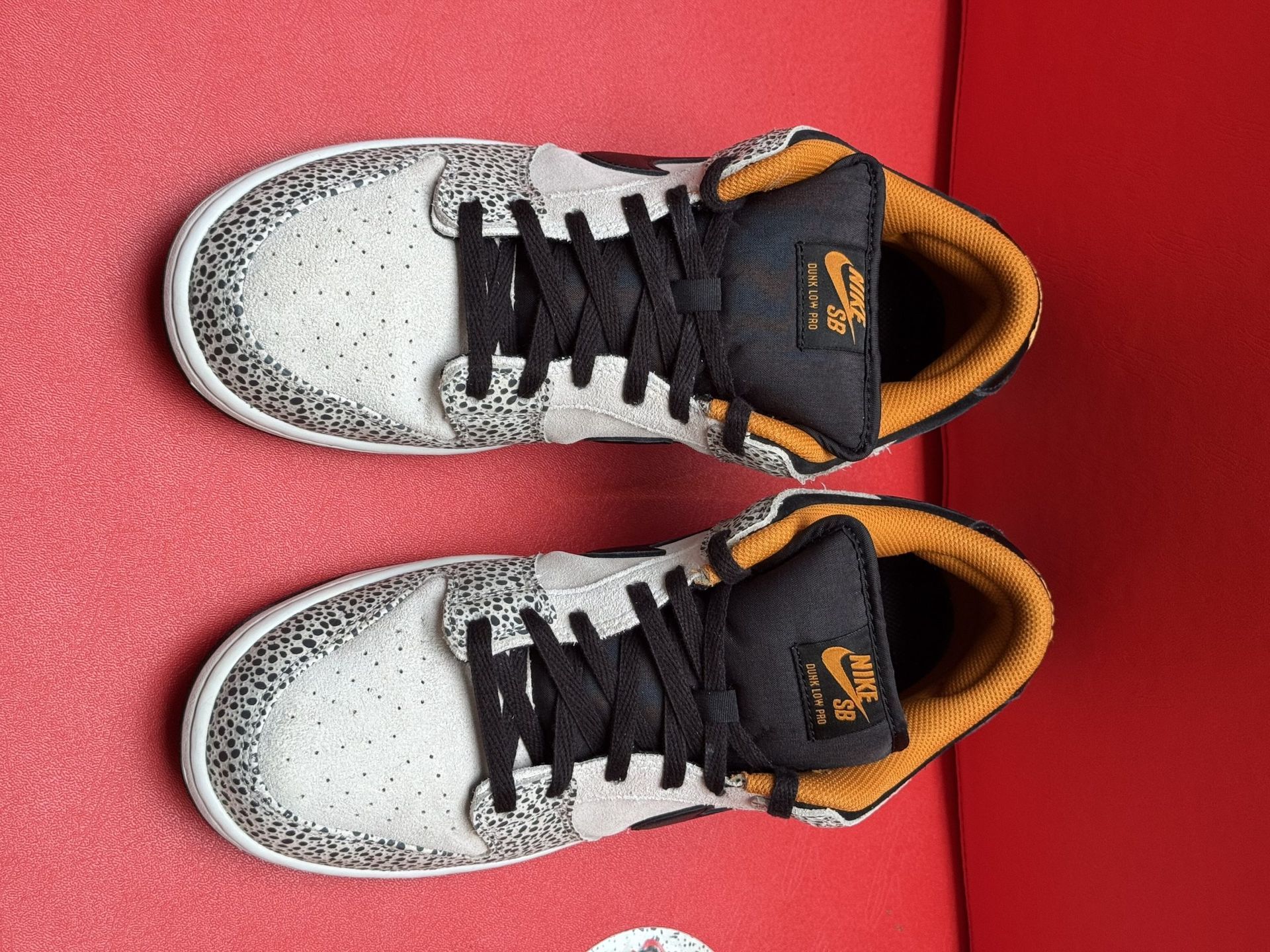 Nike SB Dunk Low sneakers with speckled pattern, black swoosh, and gold accents.