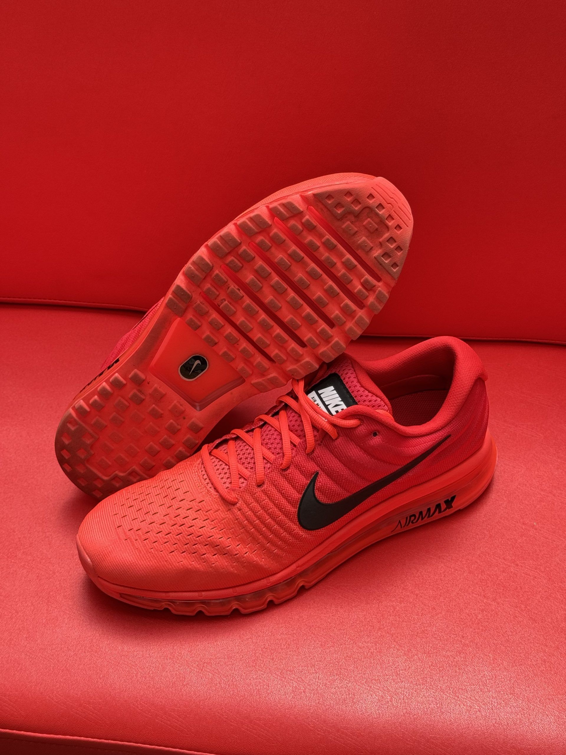 Red Nike sneakers on a red surface, with the sole visible.