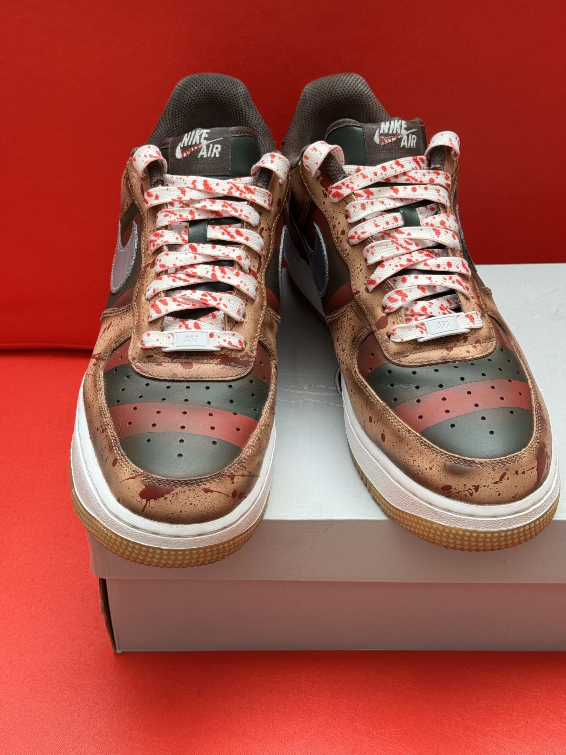 Custom Nike Air Force 1 sneakers with Freddy Krueger design on white box, red background.