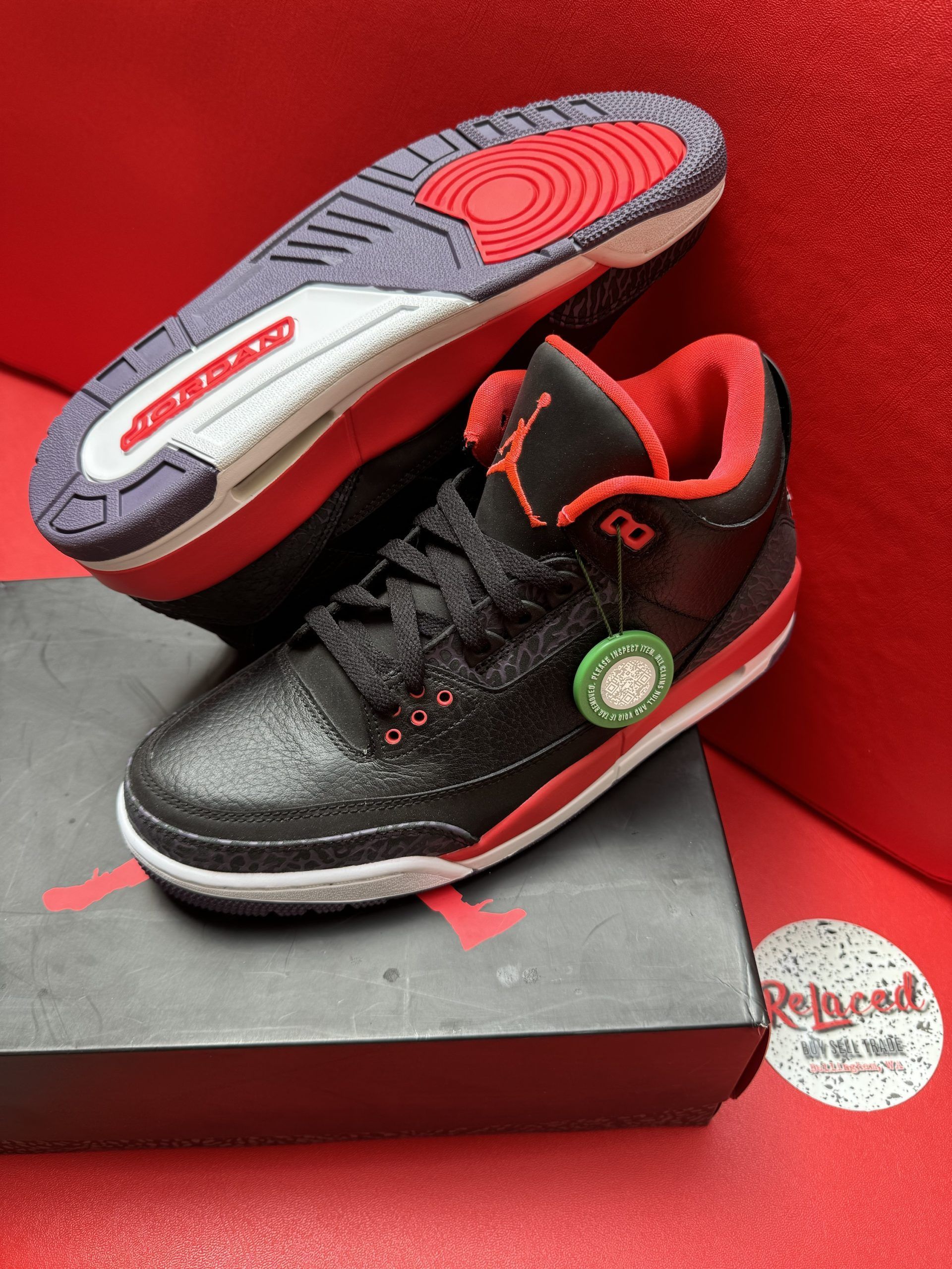 Black and red Air Jordan 3 sneakers with a matching box and a visible sole.