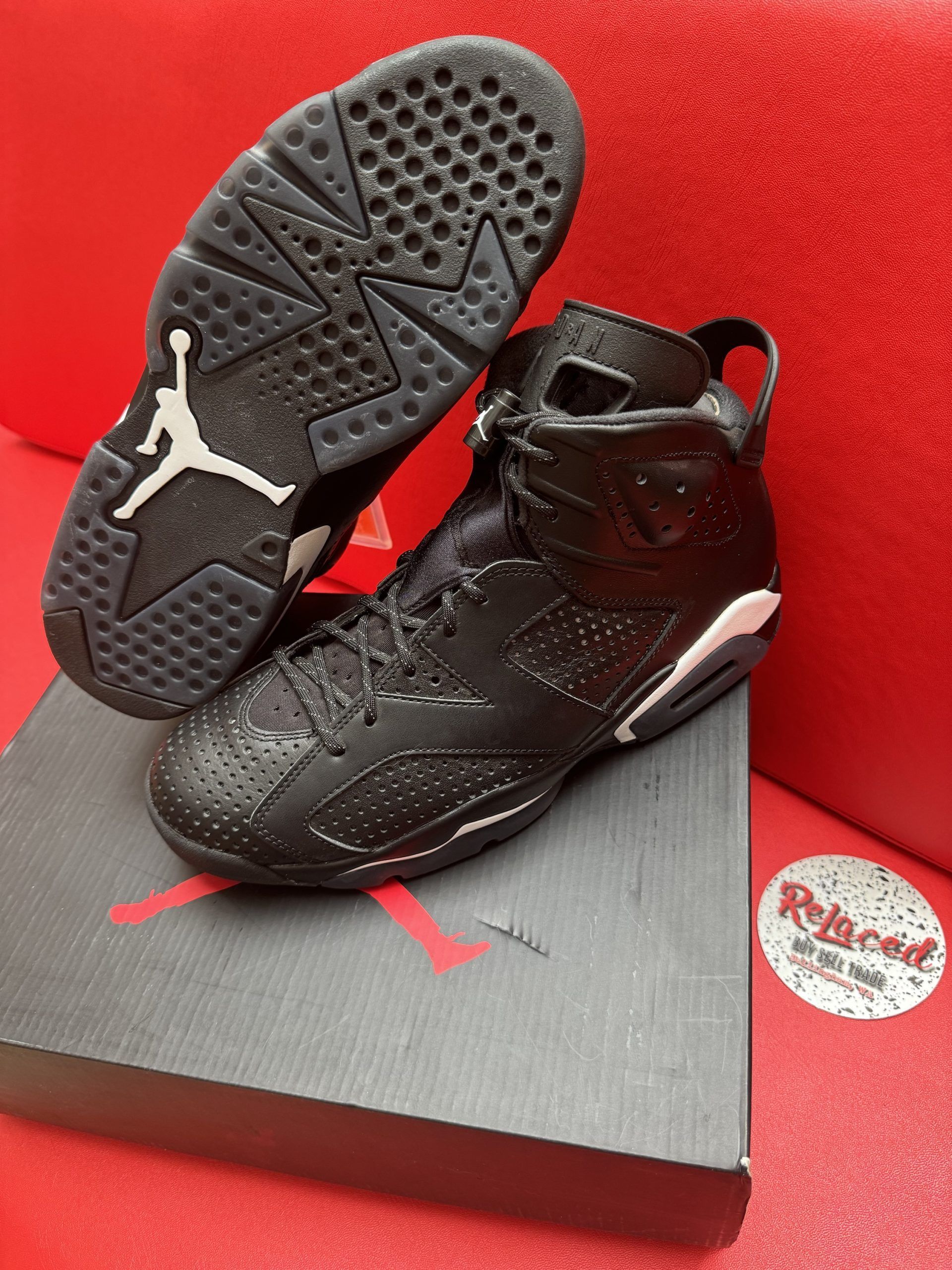 Black and white Air Jordan 6 sneakers on a box, sole visible.