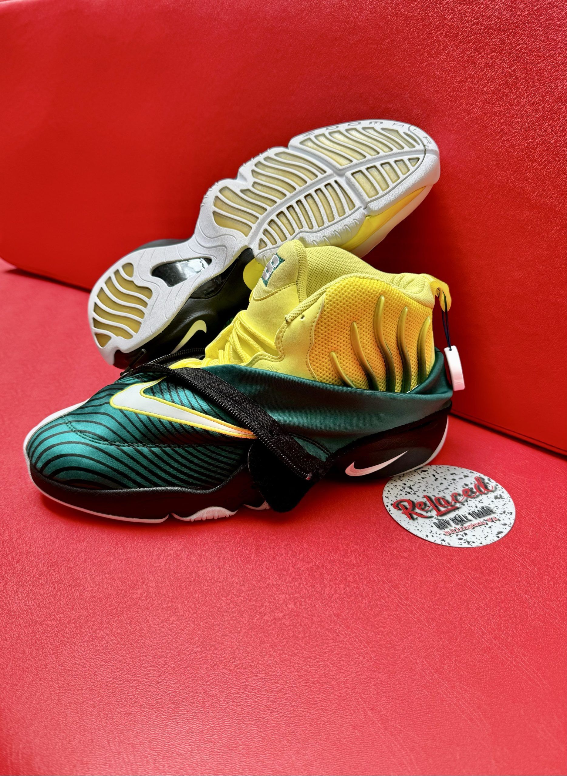 Green and yellow Nike Zoom Flight 95 sneakers on red surface.