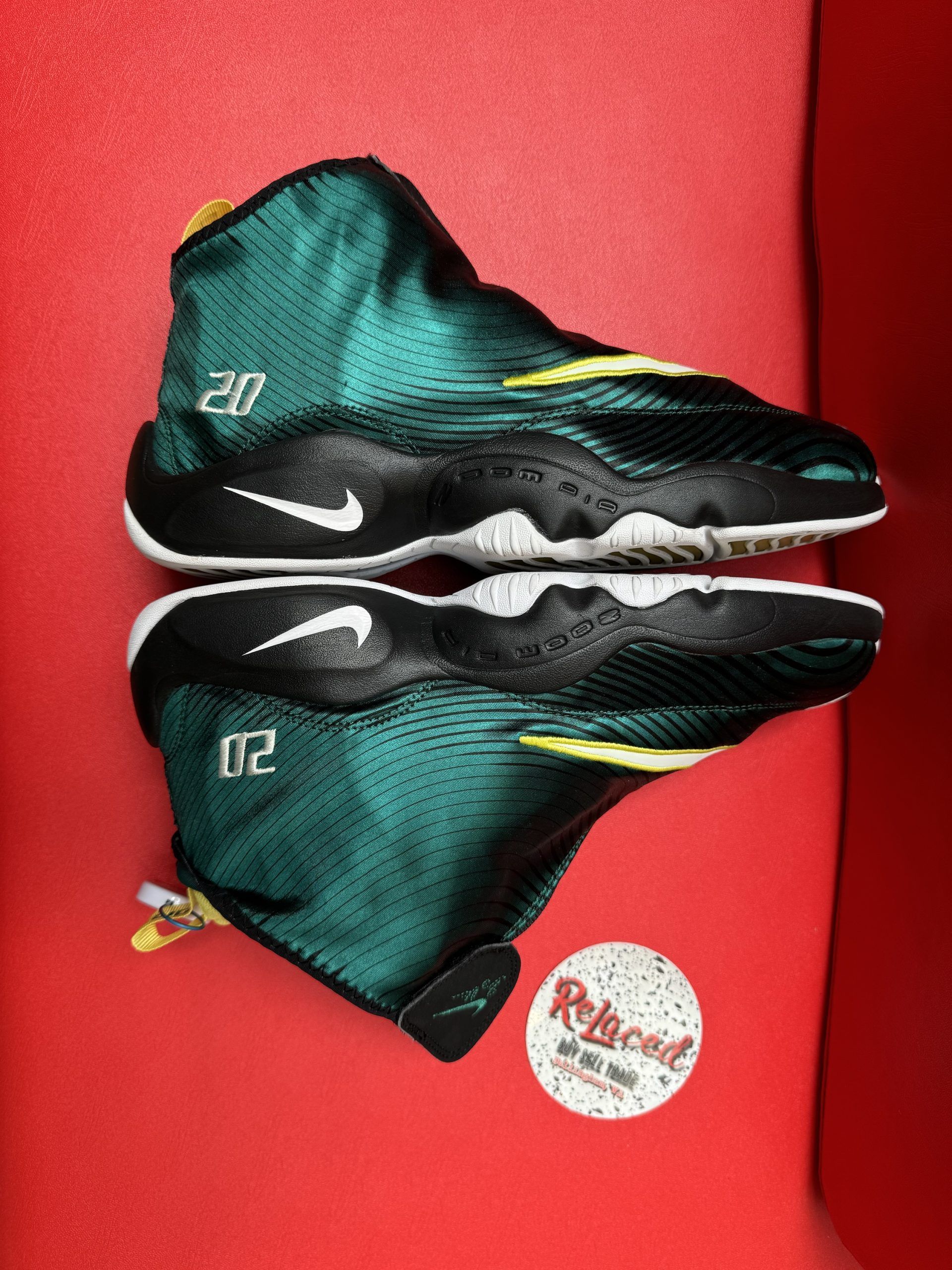 Green and yellow Nike Zoom Flight 95 sneakers on red surface.