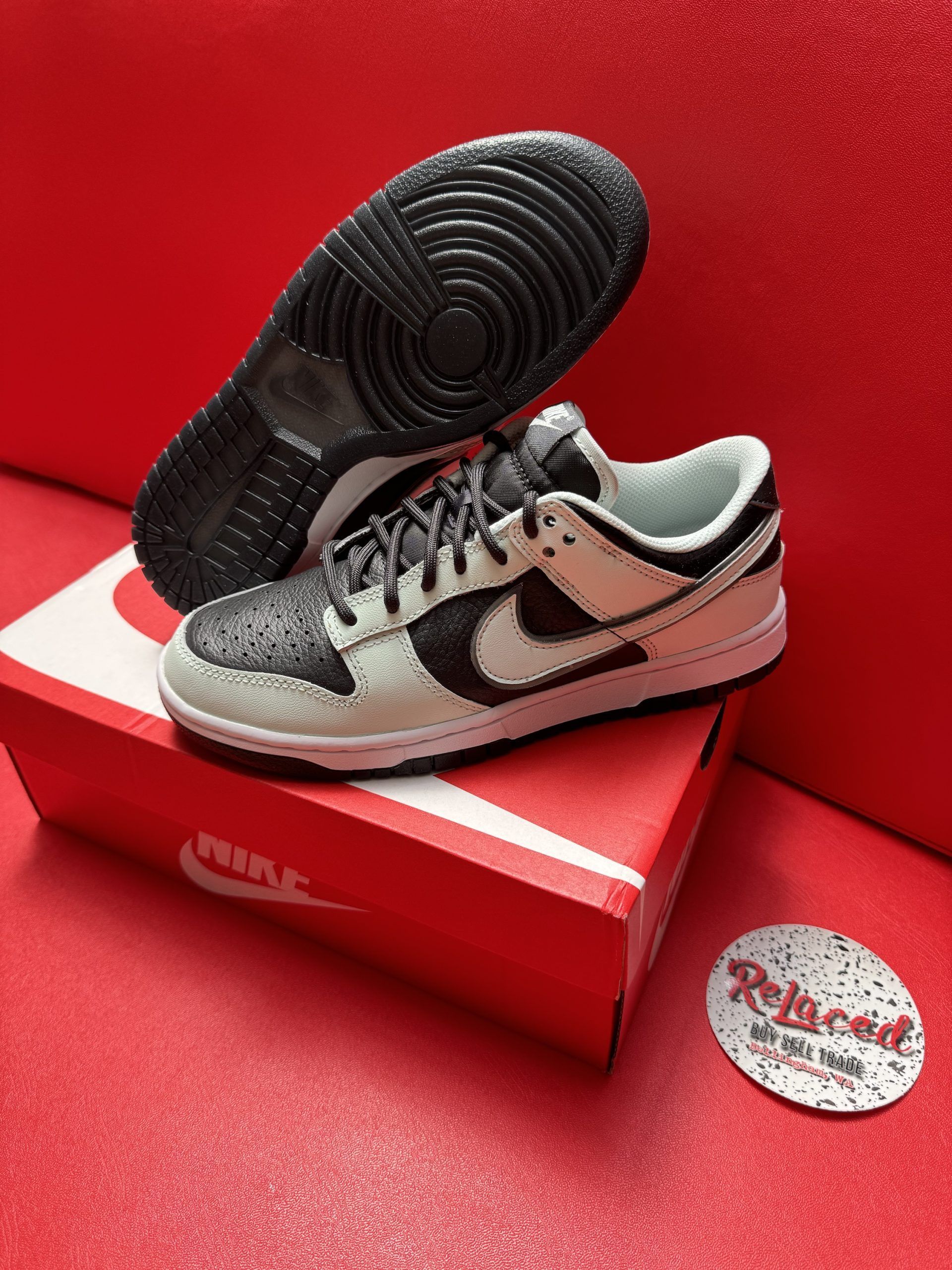 Nike Dunk Low sneakers with black and white colorway on a red box.