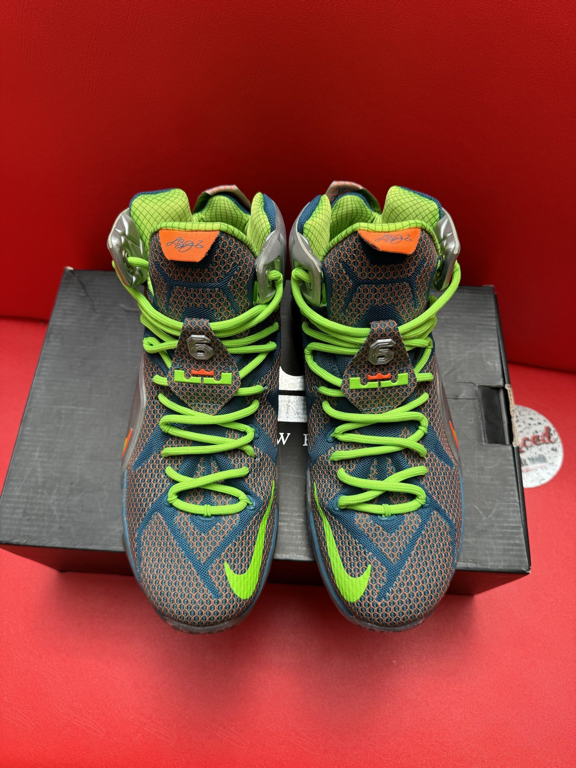 LeBron James Nike basketball shoes on box; multi-colored soles and neon green laces.