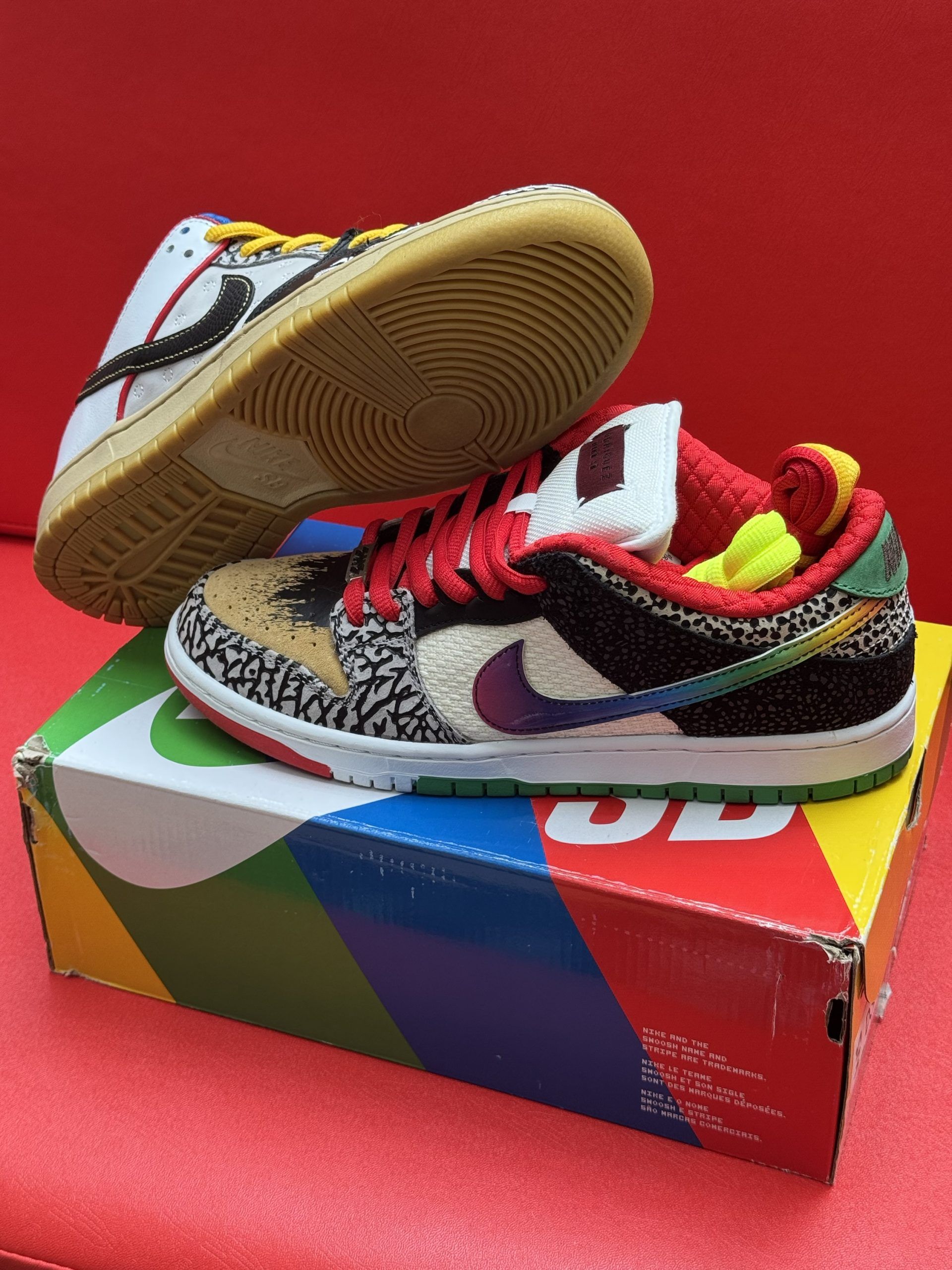 Nike Dunk Low sneakers, multi-colored on a box with rainbow stripes.
