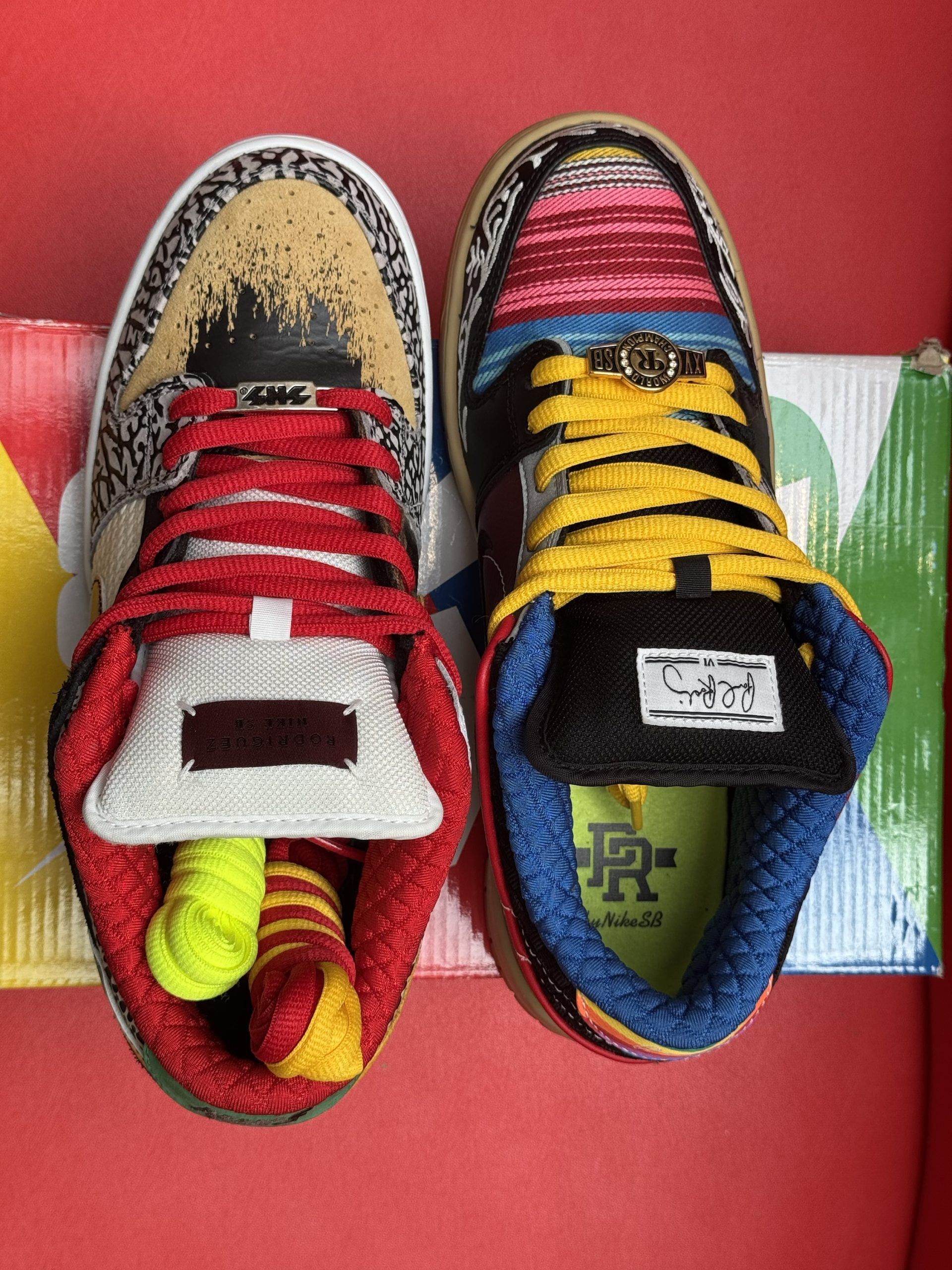 Nike Dunk Low sneakers, multi-colored on a box with rainbow stripes.