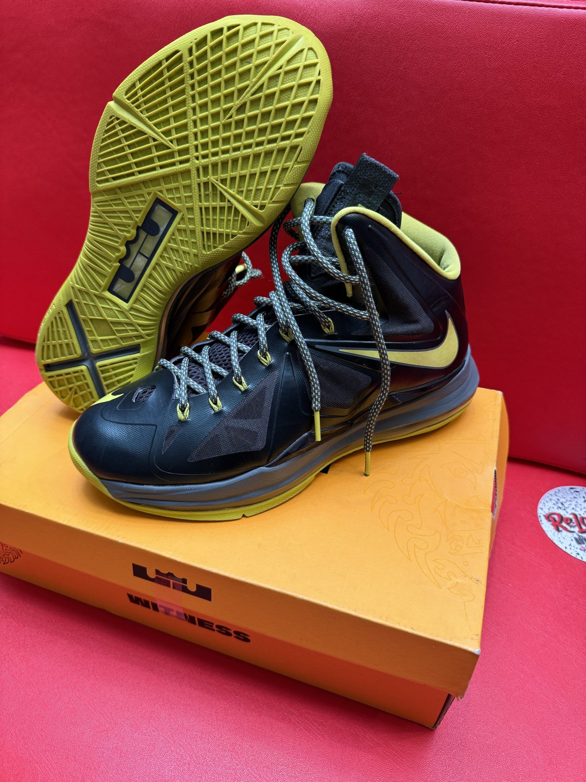Black and yellow LeBron basketball shoes on a box, sole up.