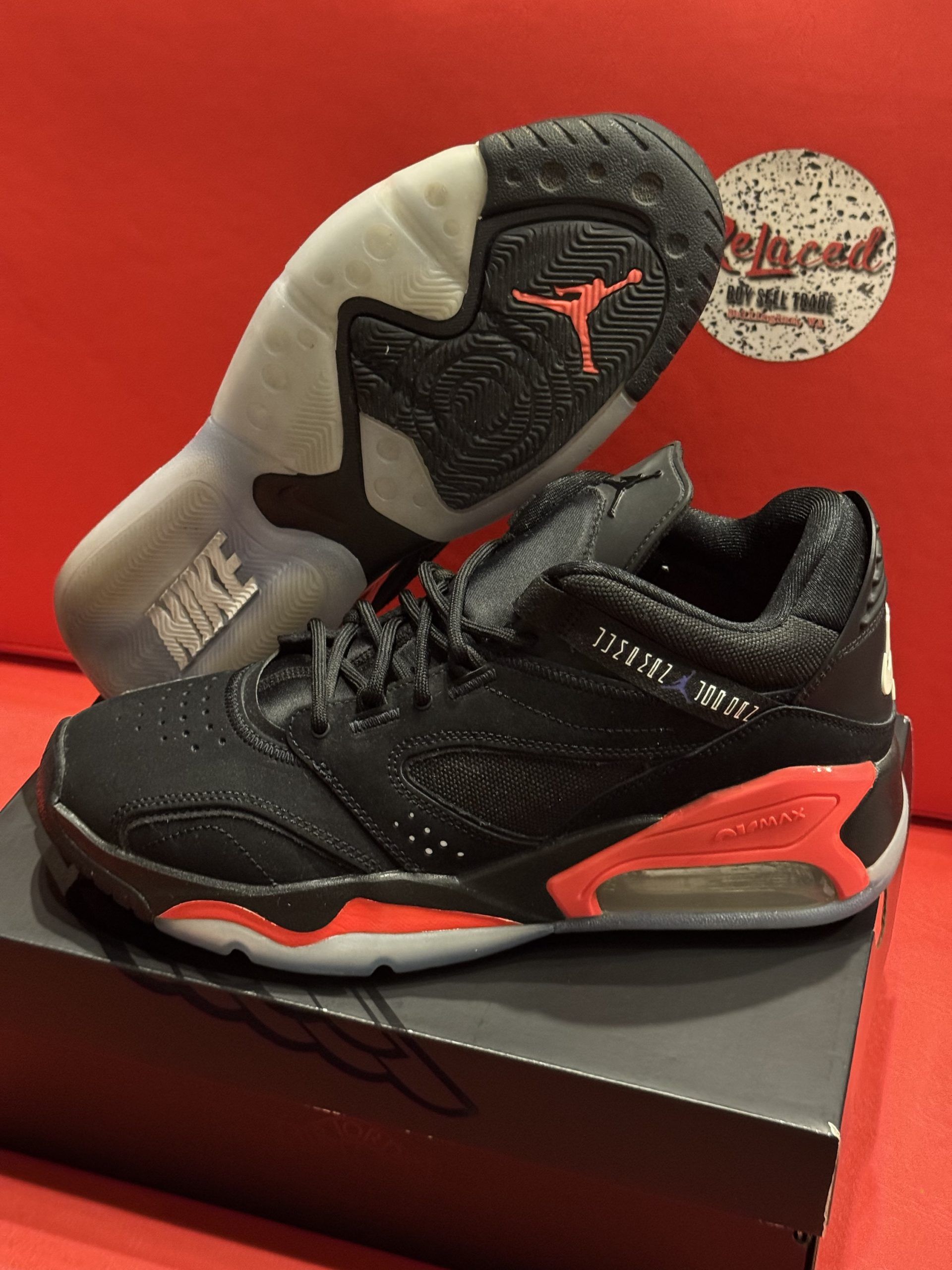 Black and red Jordan sneakers on a shoebox. The sole is visible with the iconic Jumpman logo.