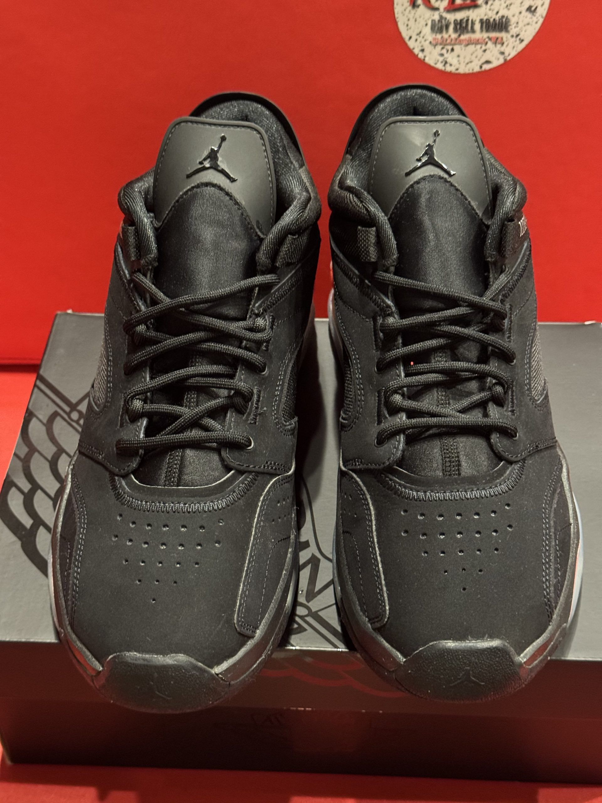 Black and red Jordan sneakers on a shoebox. The sole is visible with the iconic Jumpman logo.