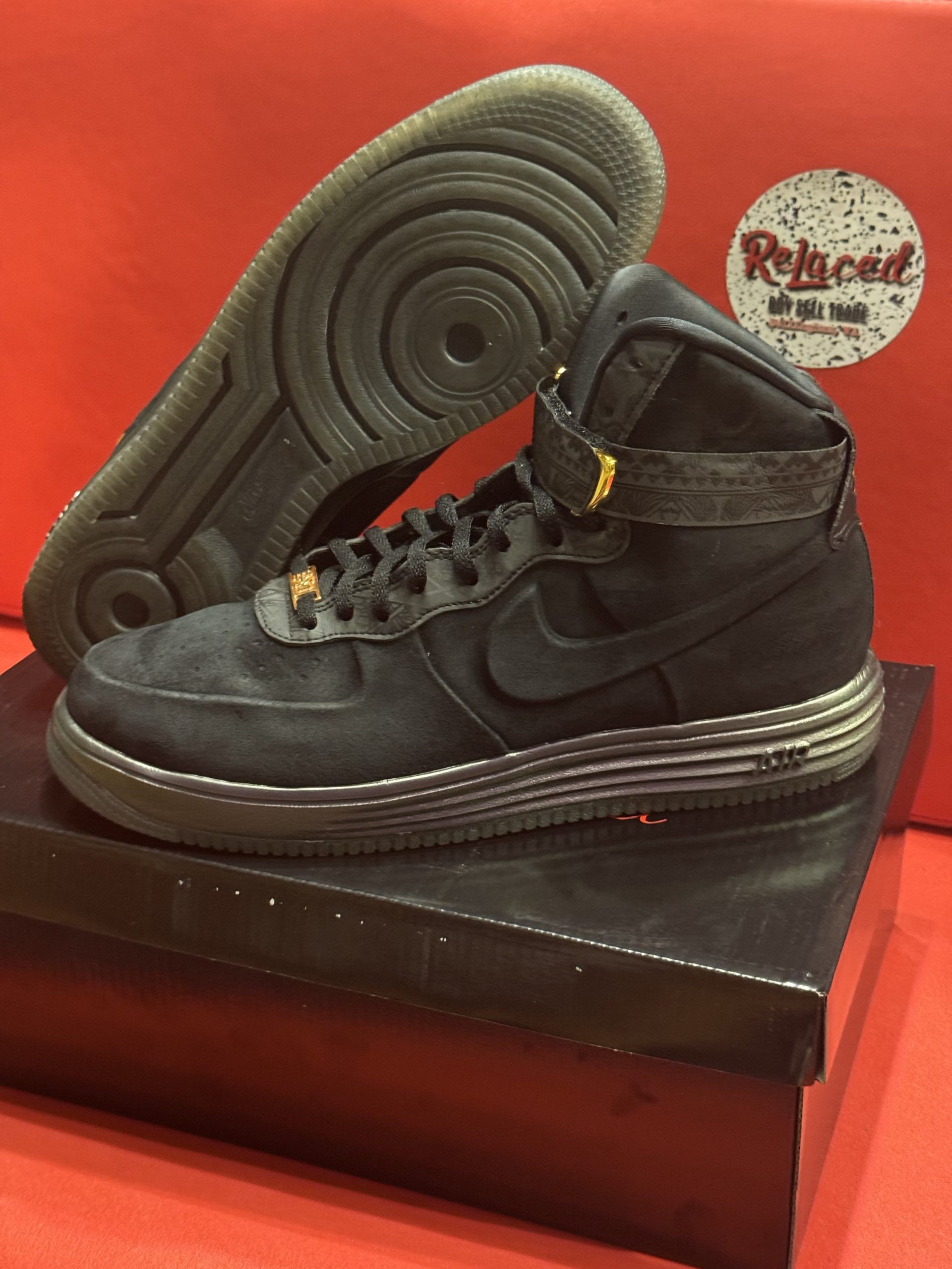 Black and purple Nike Air Force 1 Lunar sneakers with a high top, resting on a shoebox.