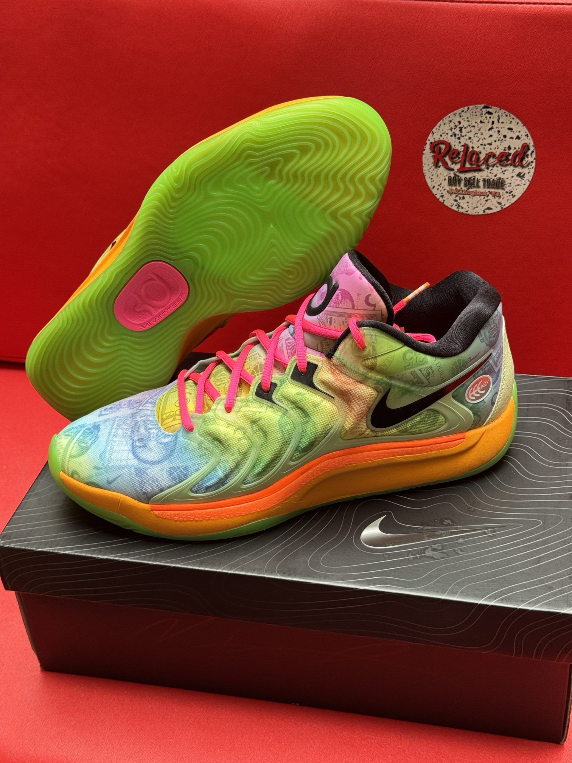 Colorful Nike basketball shoes with swirling patterns and neon accents, resting on a box.