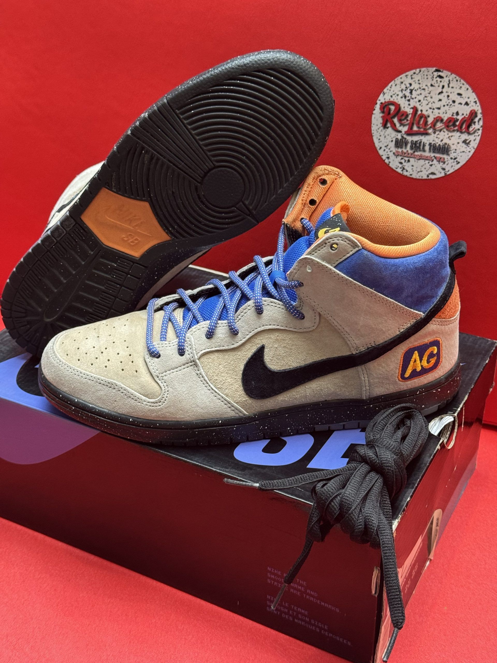 Nike Dunk high-top sneaker in tan, black, and blue. Black sole with orange accents. 