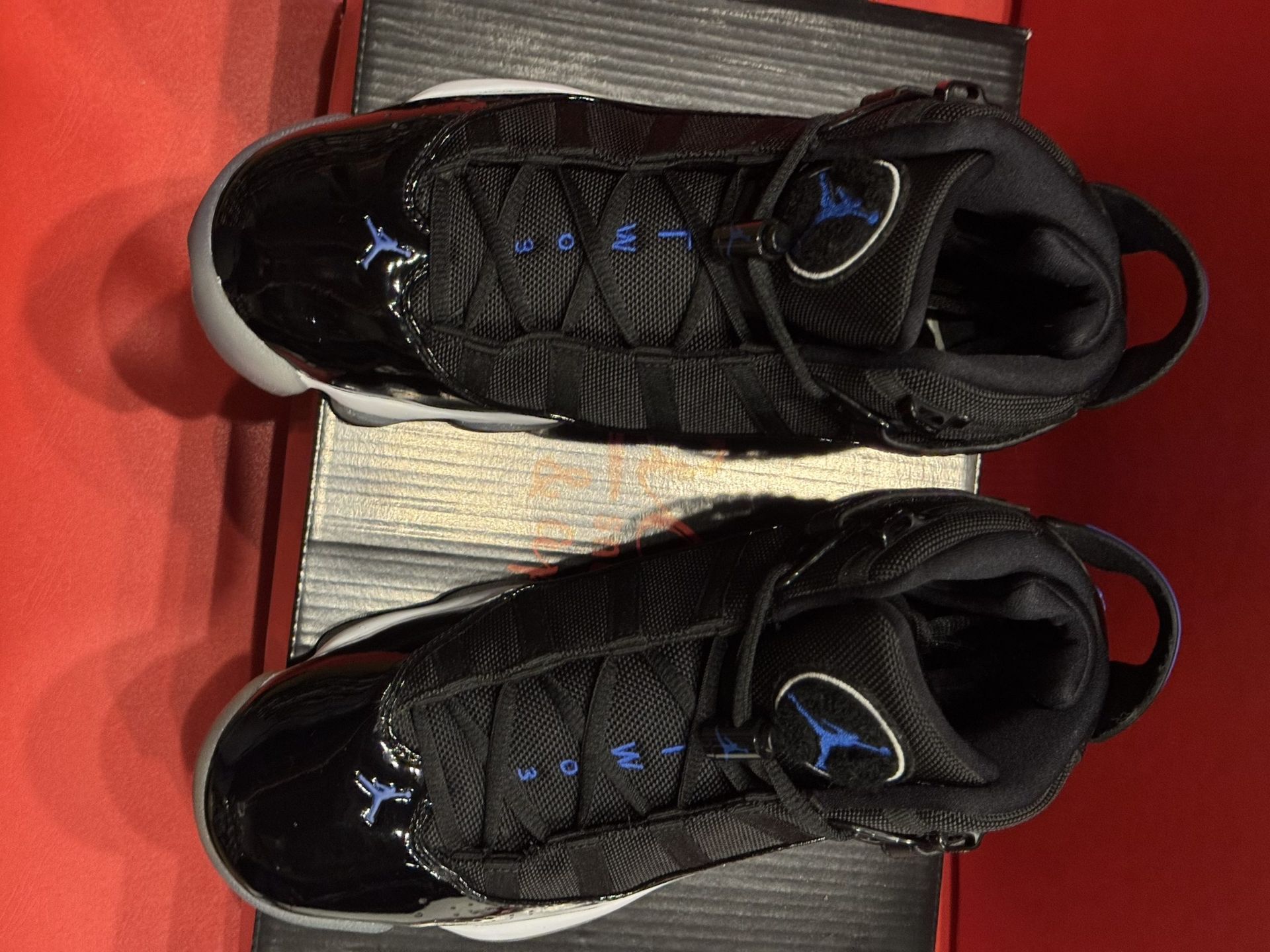 Black and blue sneakers on a shoe box, sole visible.