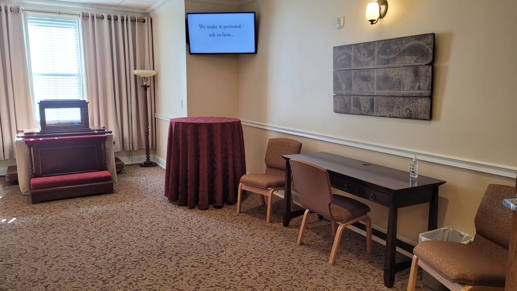 Highland Funeral Home Hallway with Desk, Table and TV on the Wall