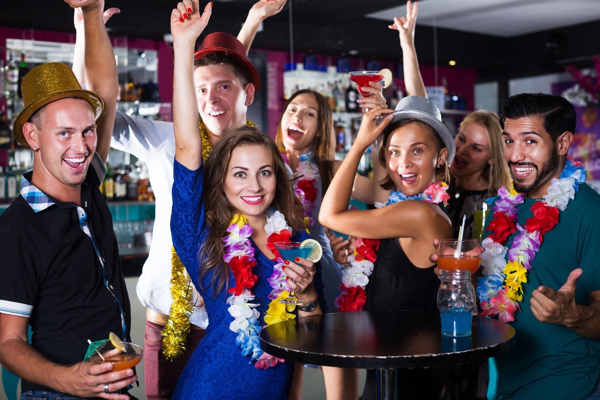 A group of people are standing around a table at a party.