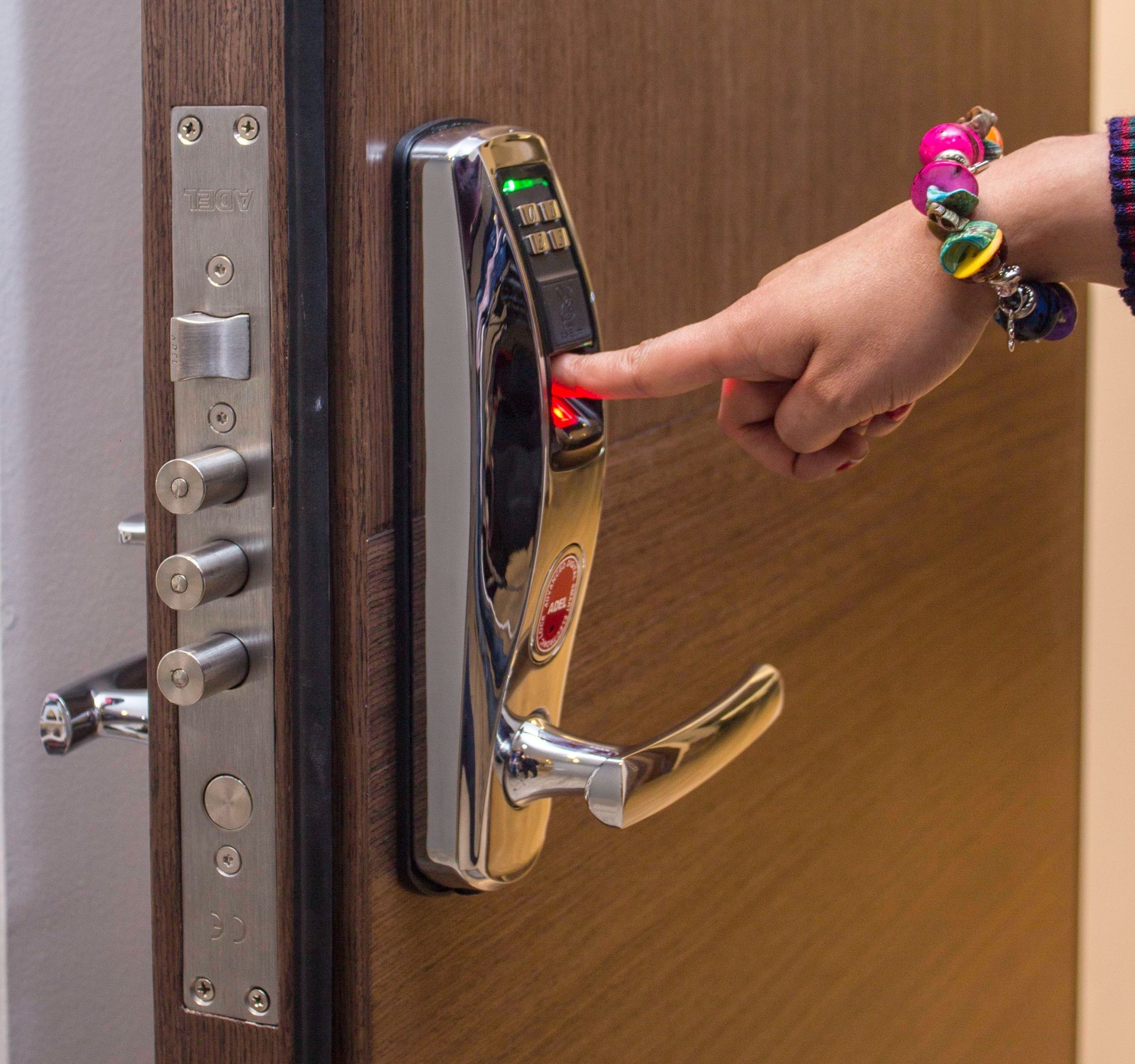 A person is pressing a button on a door lock