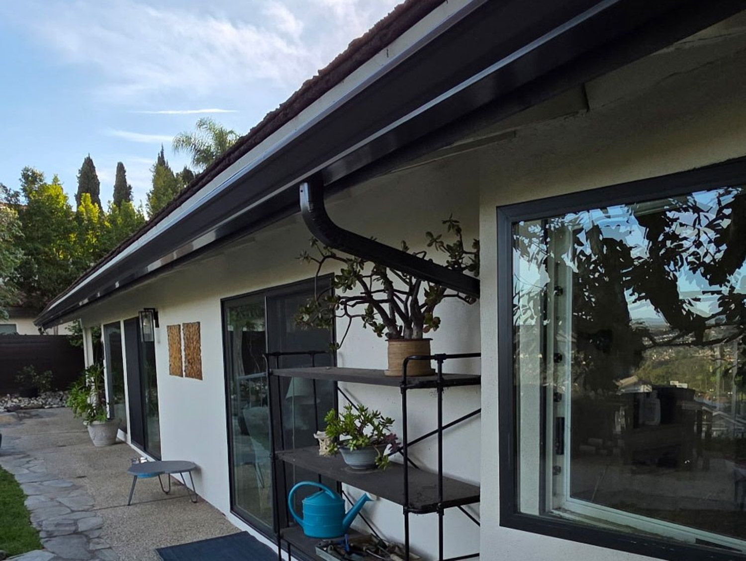 Exterior of a Reno home with new black seamless gutters professionally installed by Gutter Specialis