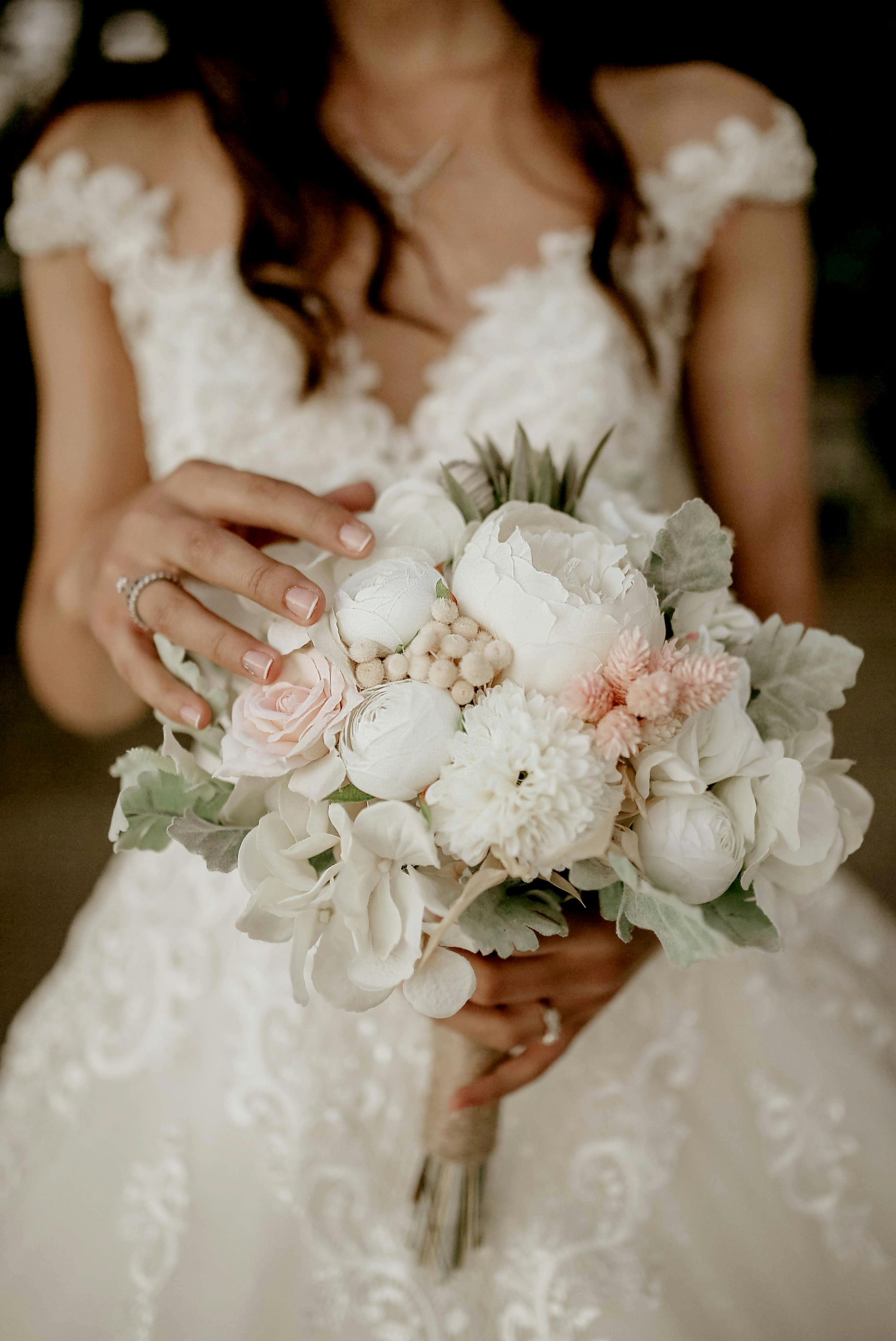 A bride in a white dress is holding a bouquet of flowers.