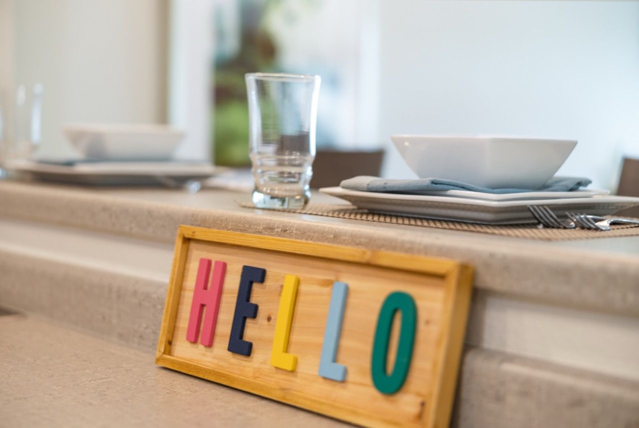 Colorful wooden HELLO sign on a kitchen counter in a modern apartment.