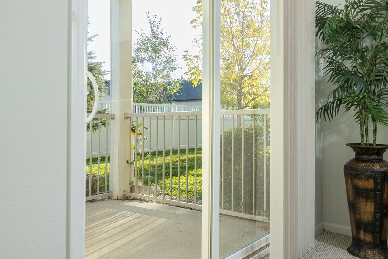 Interior view of a sliding glass door opening to a small balcony with a white railing.
